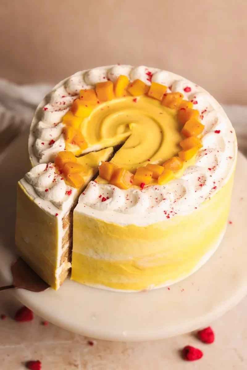 Mango lassi cake decorated with mango and raspberry