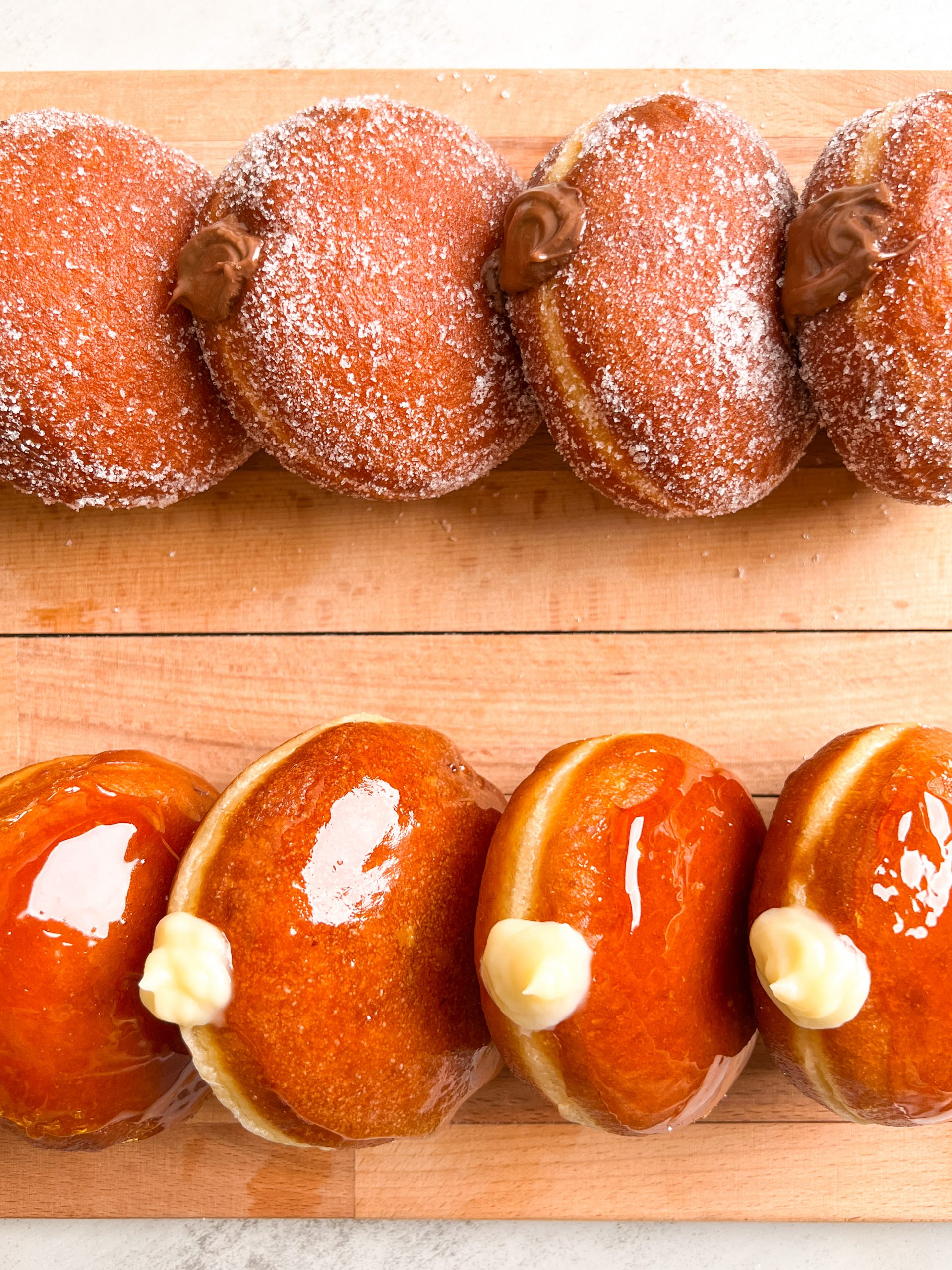 Stacked nutella donuts with sugar coating on the top, and creme brulee donuts with caramel coating on the bottom