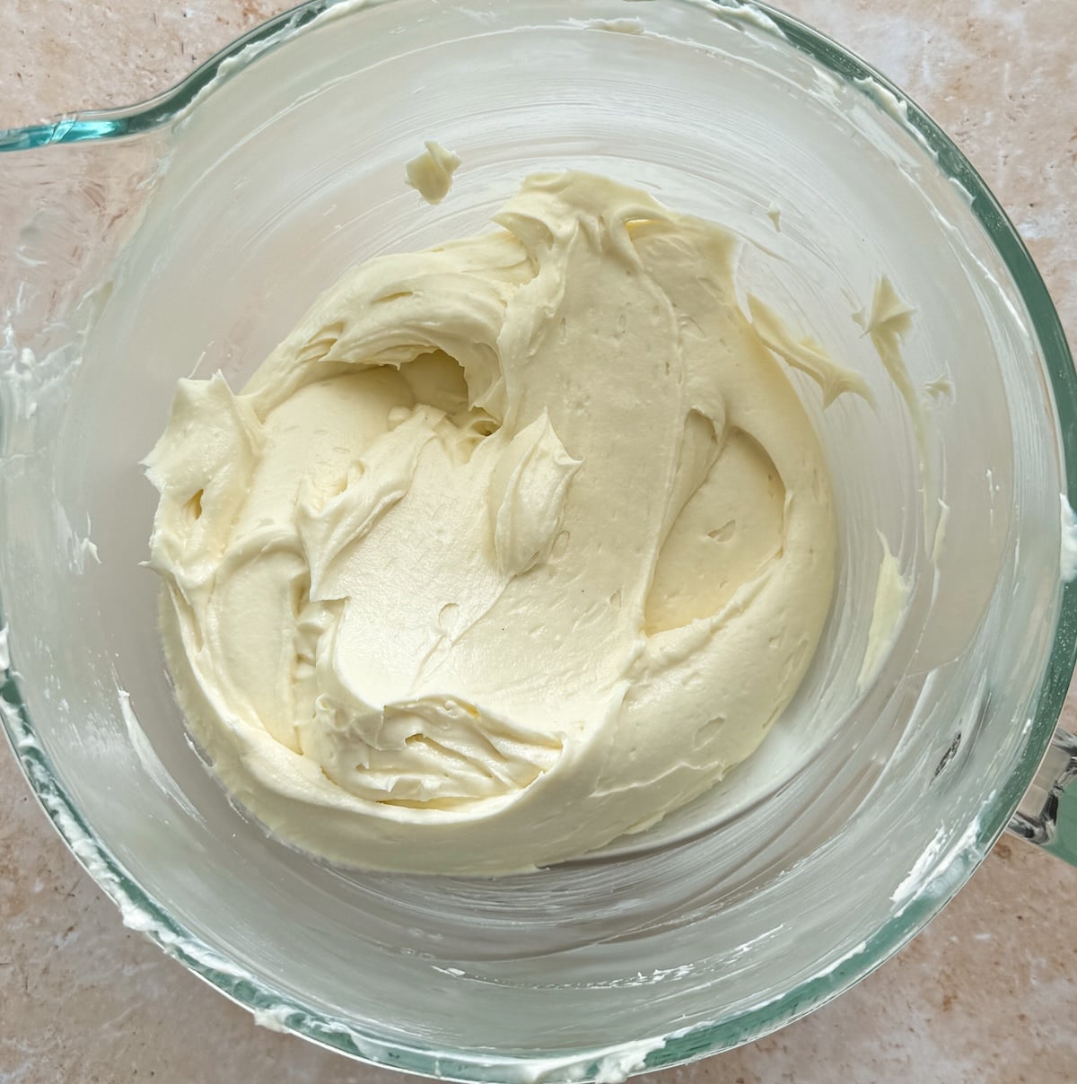A glass bowl filled with whipped cream cheese and sugar