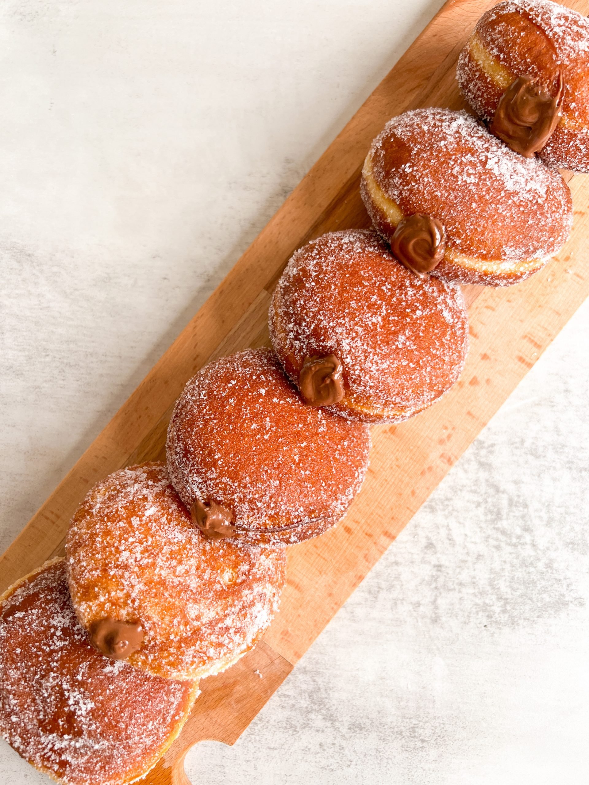 Nutella donuts stacked in a line with nutella coming out of them