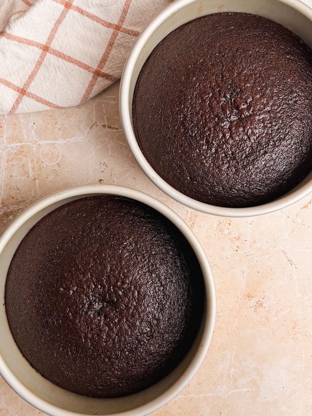 2 round cake pans with baked chocolate cake