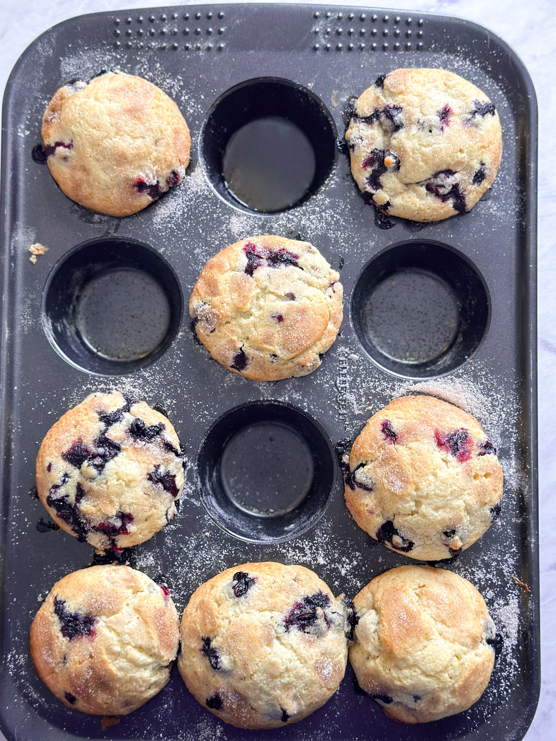 8 blueberry muffins in a muffin tray