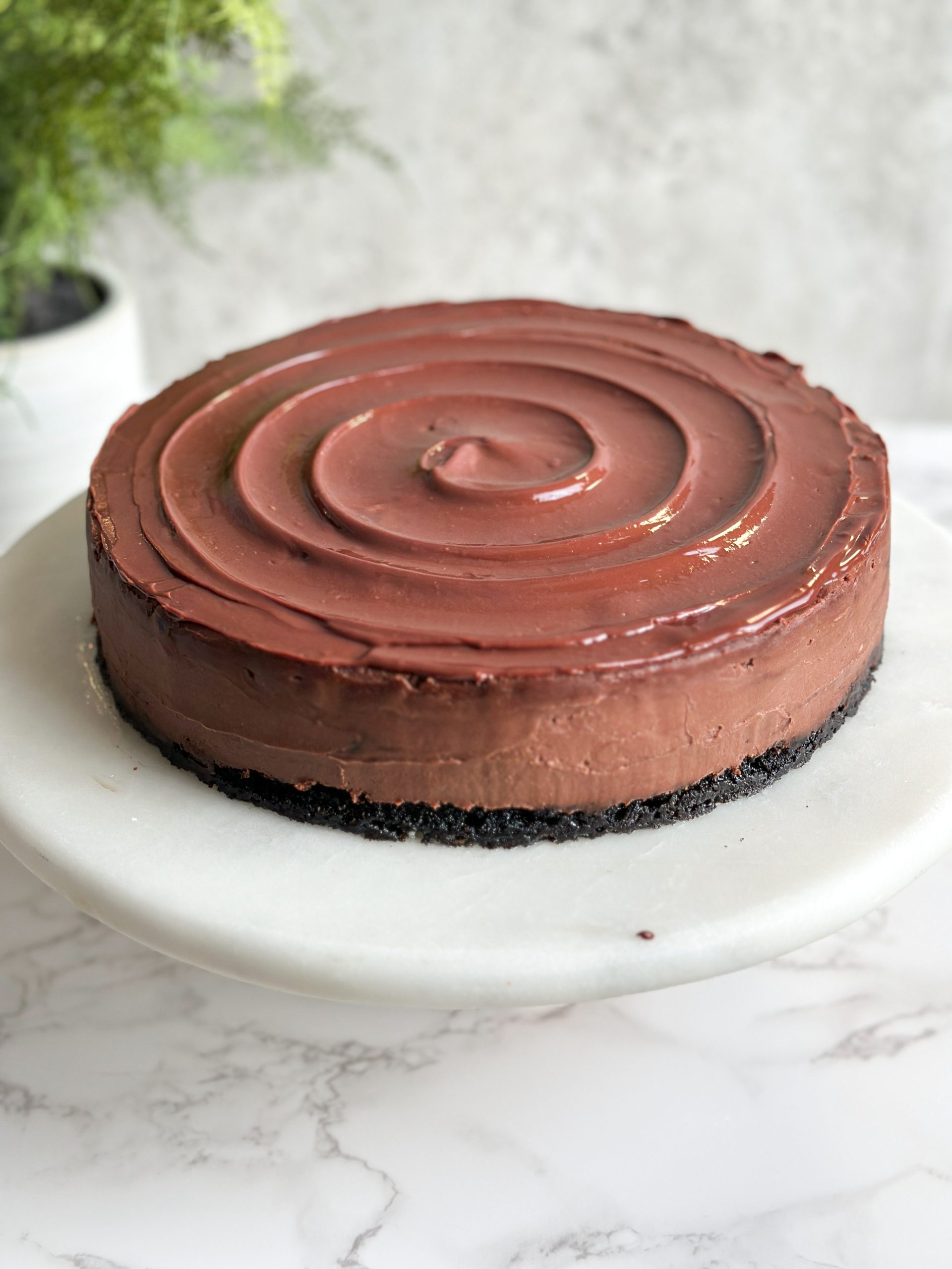 chocolate cheesecake with a shiny ganache swirl on the top 