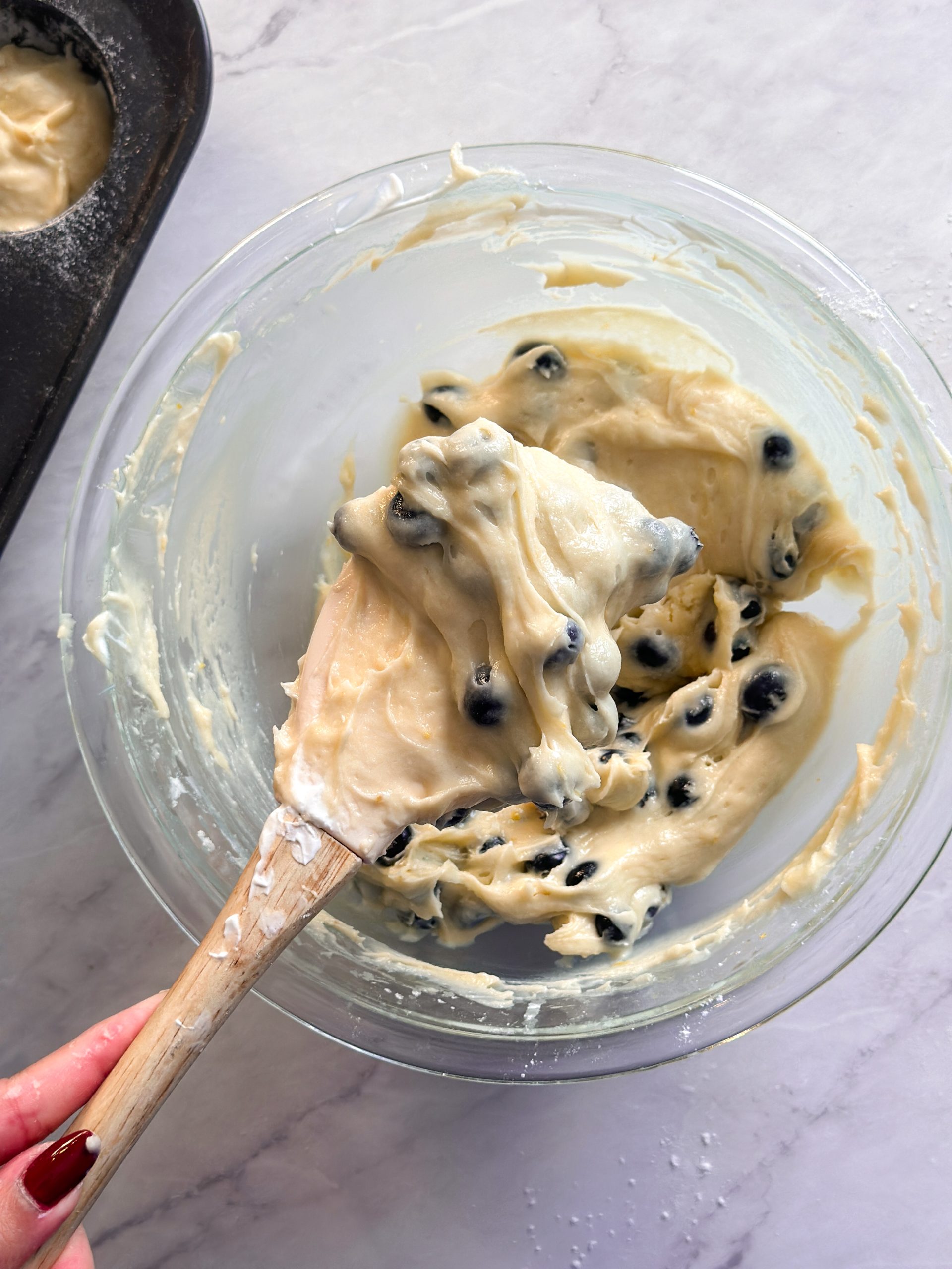 overhead picture of blueberry muffin batter in a glass bowl