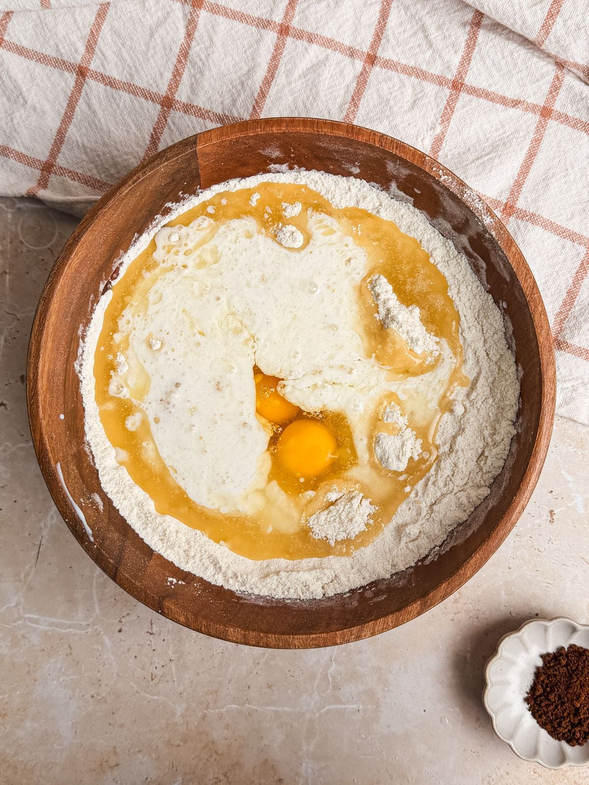 wet ingredients added into dry ingredients in a wooden bowl