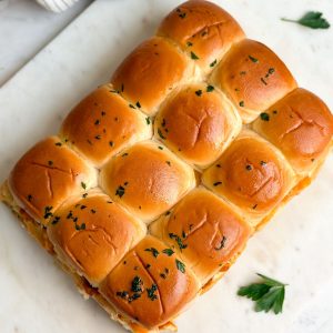 12 chicken tikka sliders on a marble serving board