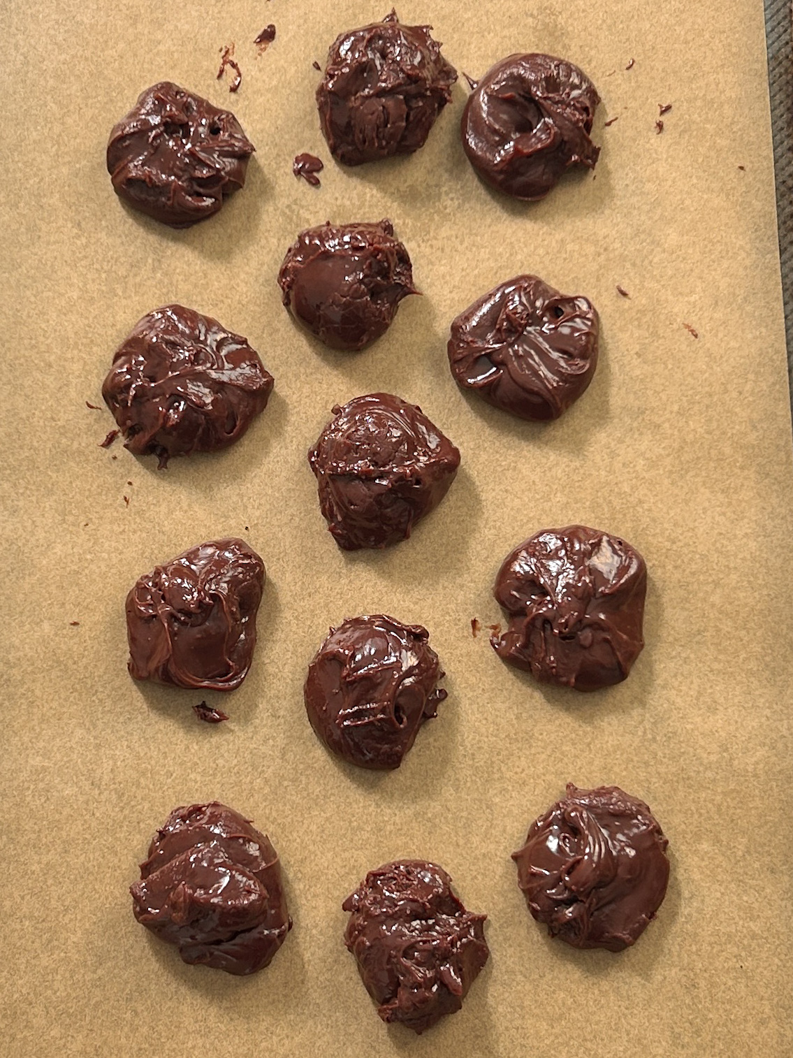 small balls of chocolate fudge on a brown parchment paper sheet