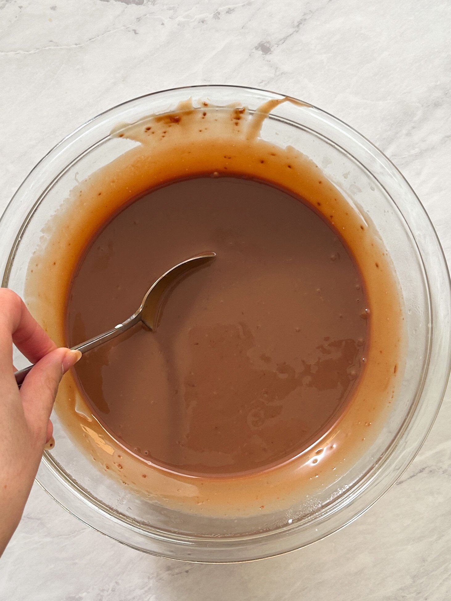 smooth and shiny chocolate ganache in a glass bowl