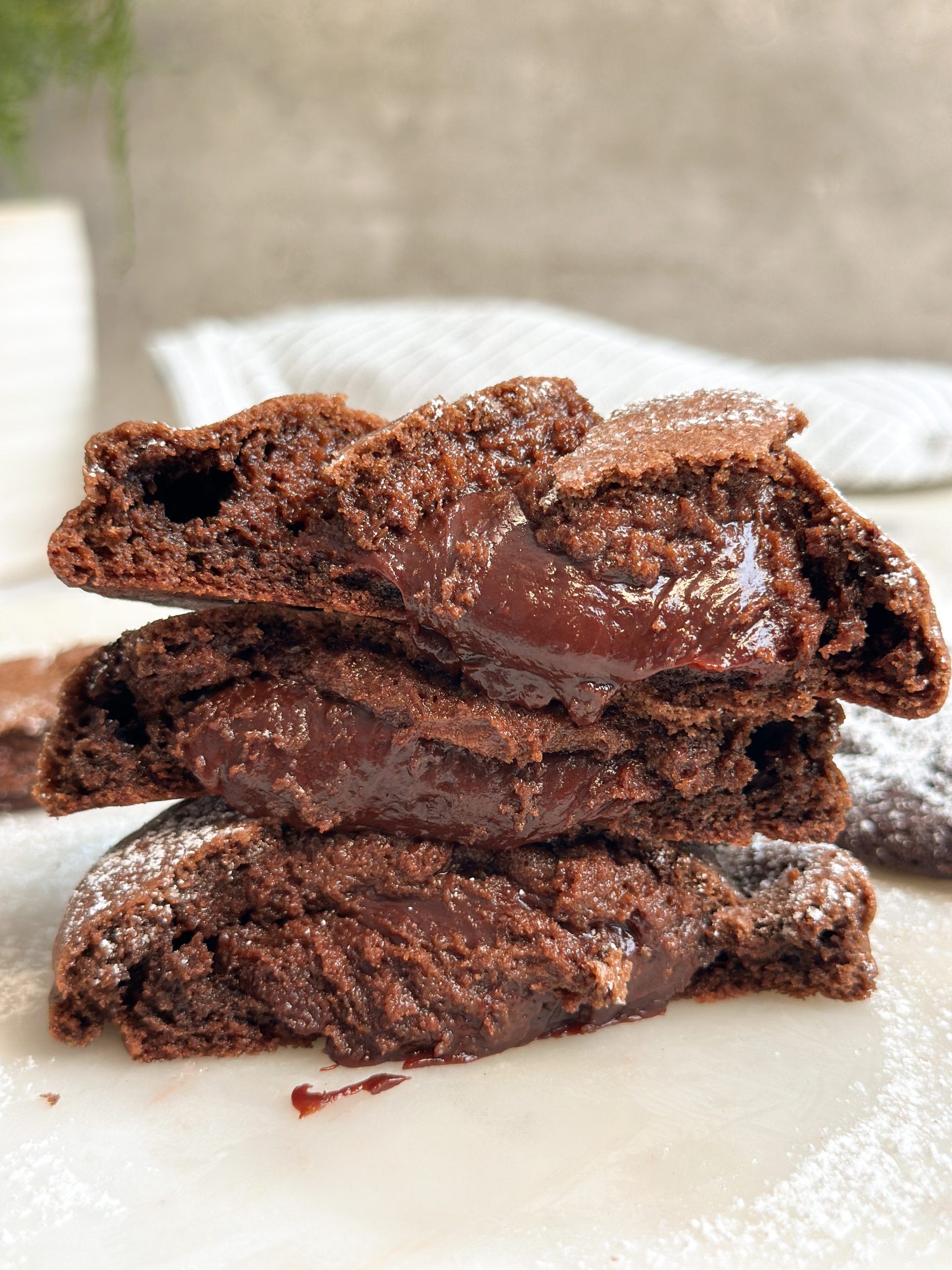 3 halves of chocolate lava cookies stacked on top of each other revealing molten interior