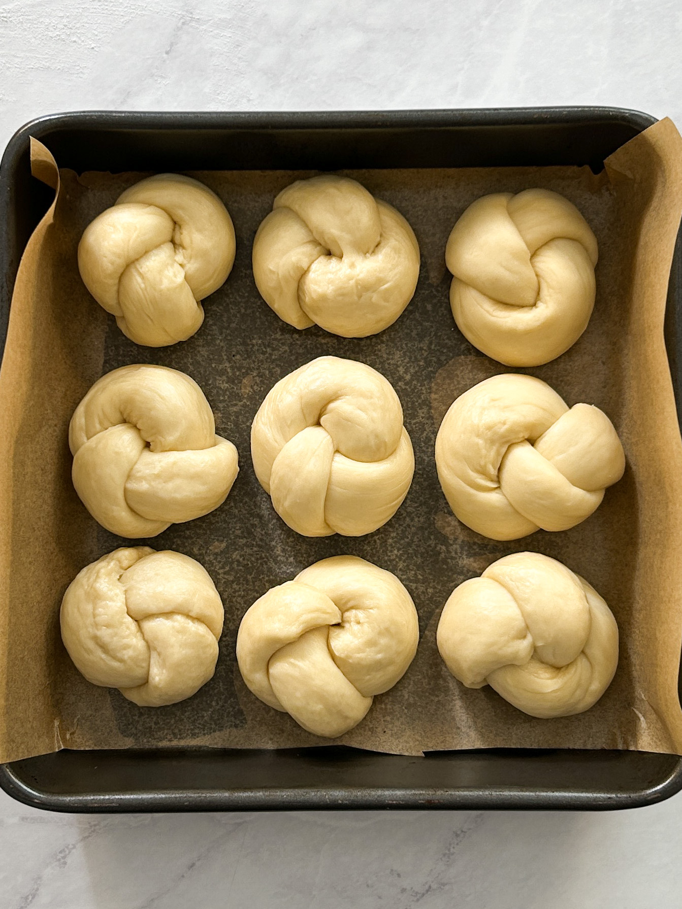 9 garlic knots in a pan before baking