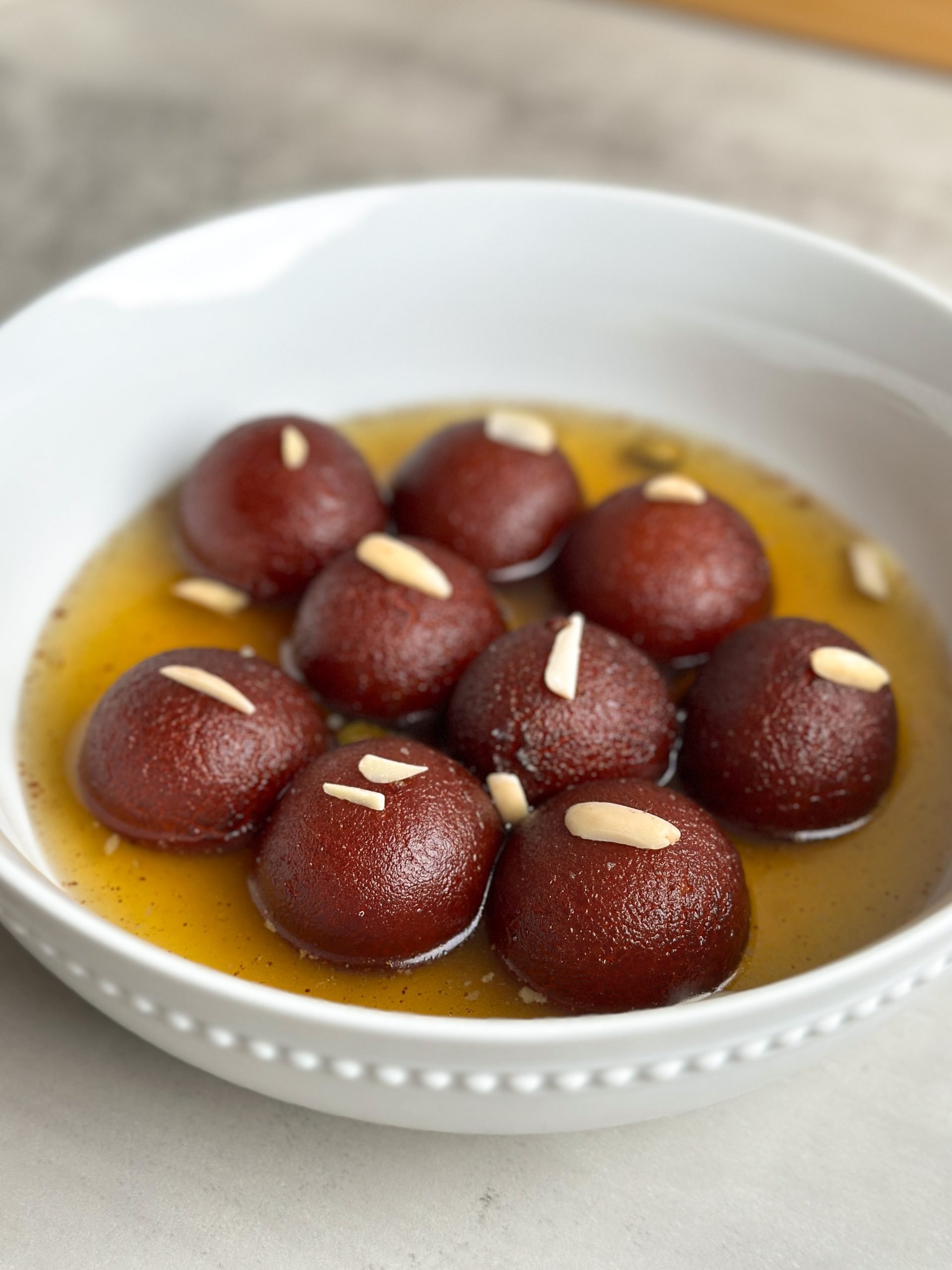 Moist brown gulab jamuns in a bowl