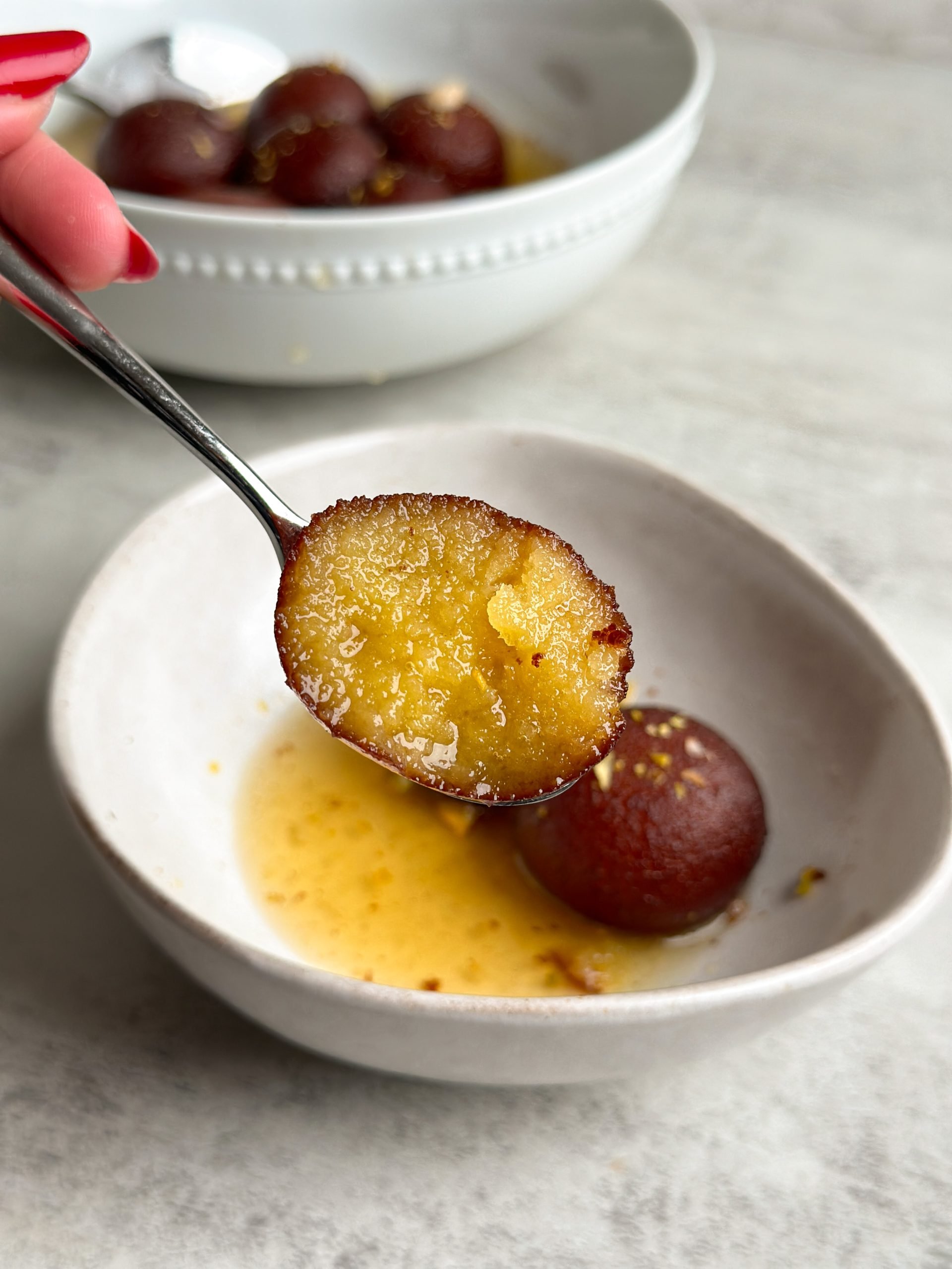 Moist brown gulab jamuns in a bowl