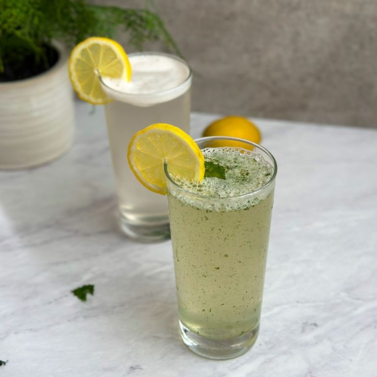 2 glasses with mint lemonade decorated with lemon slices