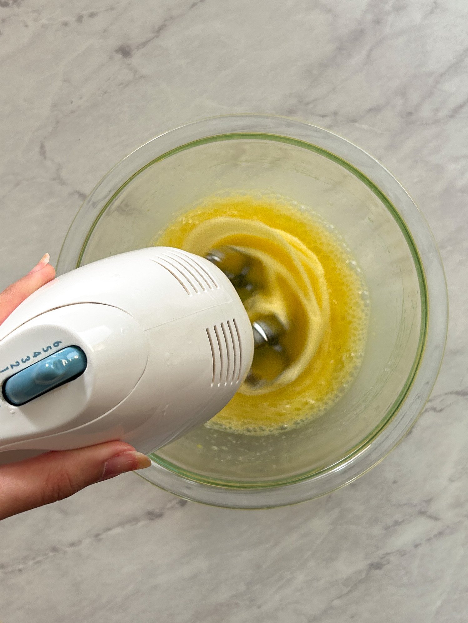 whisking eggs and sugar in a glass bowl