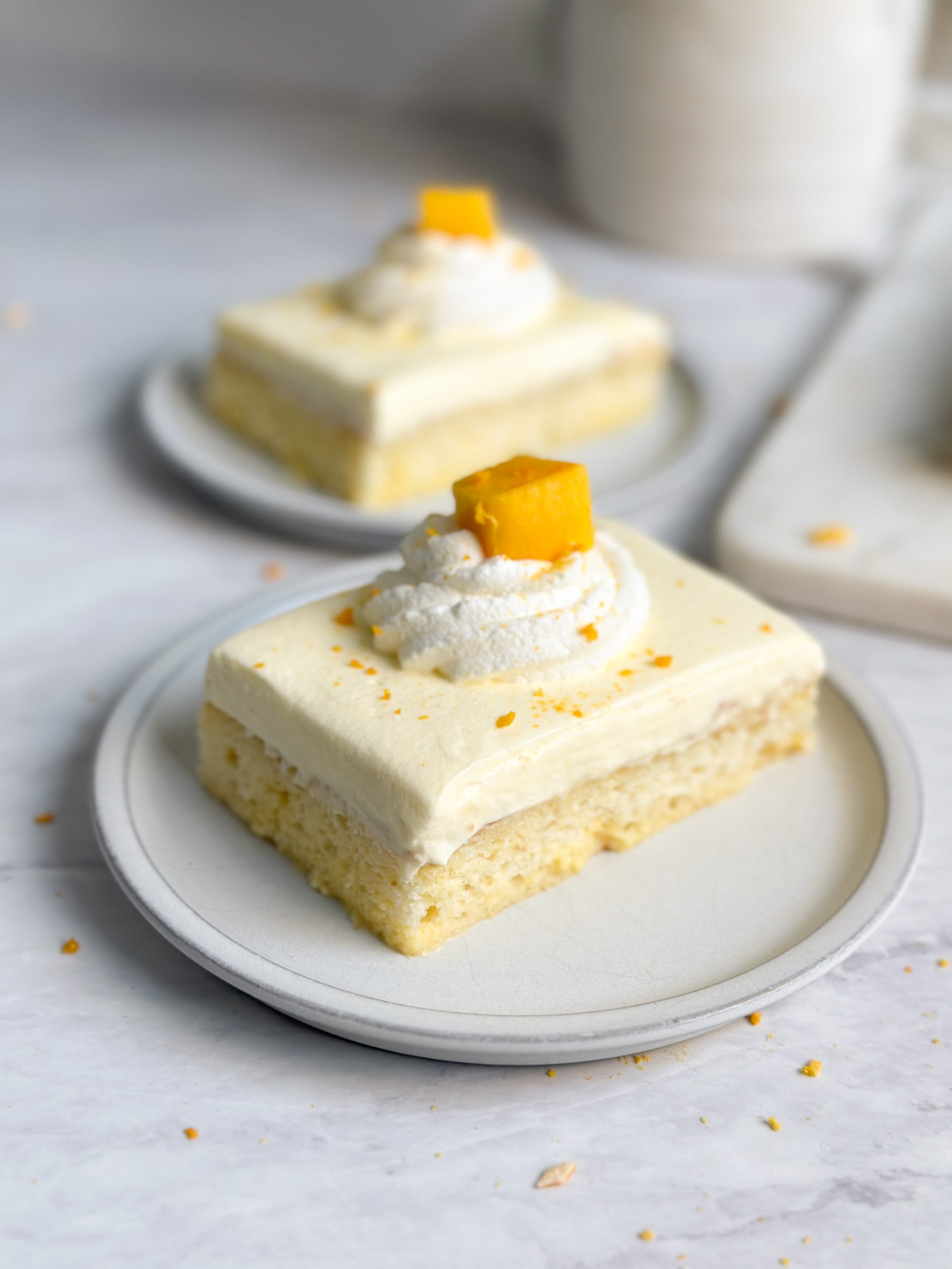 a slice of mango lassi tres leches cake on a small plate revealing moist interior