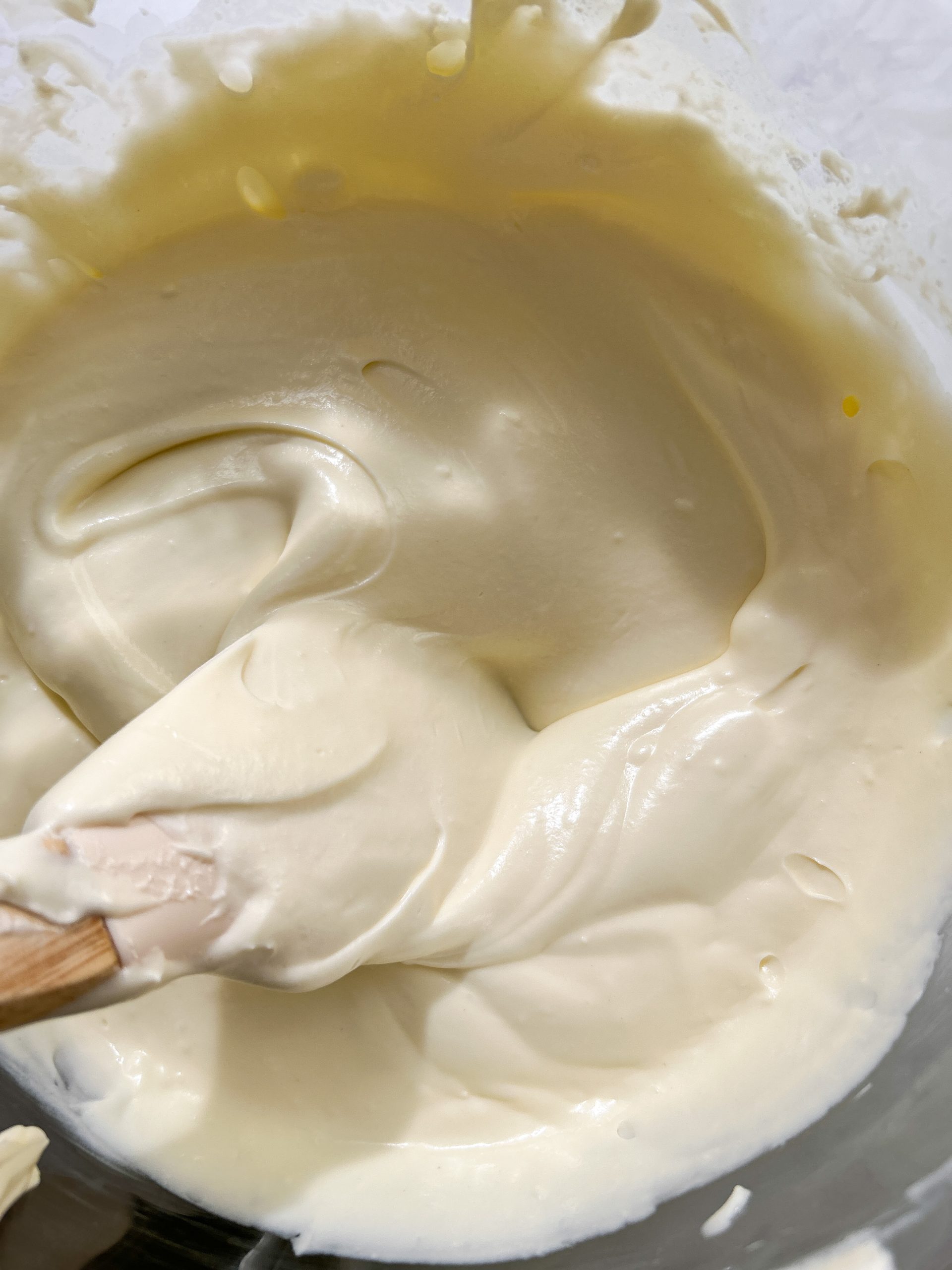 close up of smooth, thick and creamy cheesecake batter in a bowl