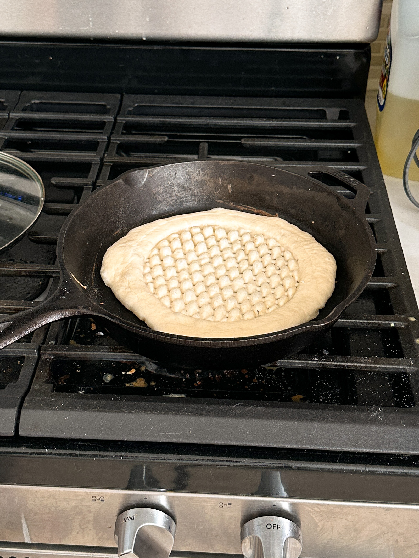 roghni naan being cooked on a cast iron skillet on the stove