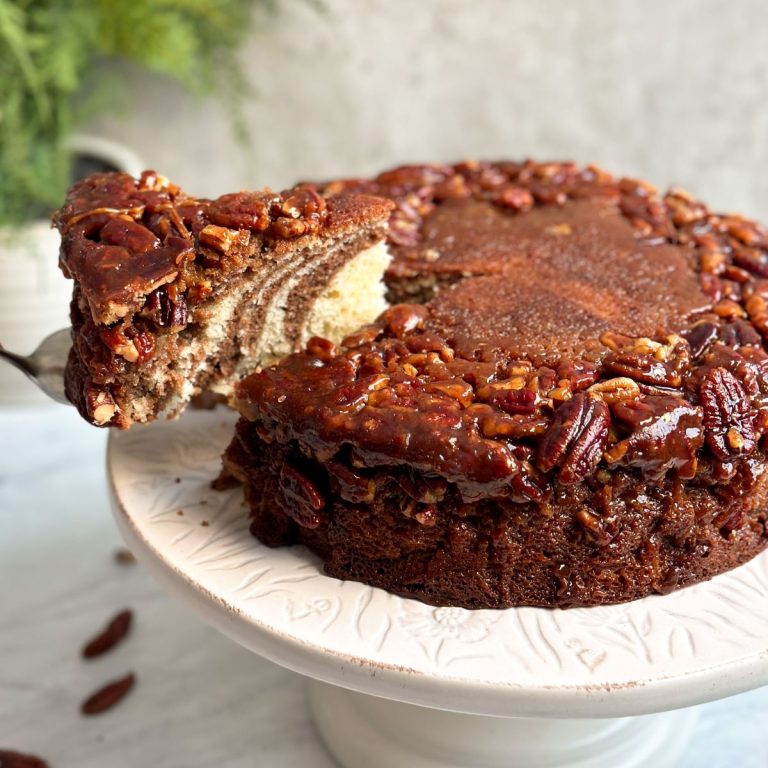 marble cake with a caramelized pecan topping and brown and white layers inside.