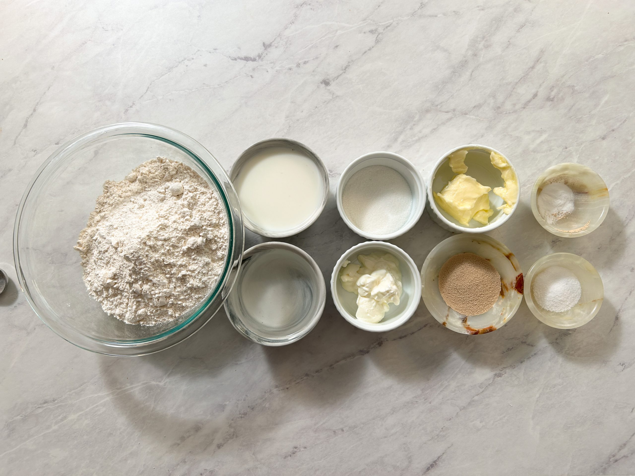 overhead picture of all the ingredients needed to make roghni naan in small bowls