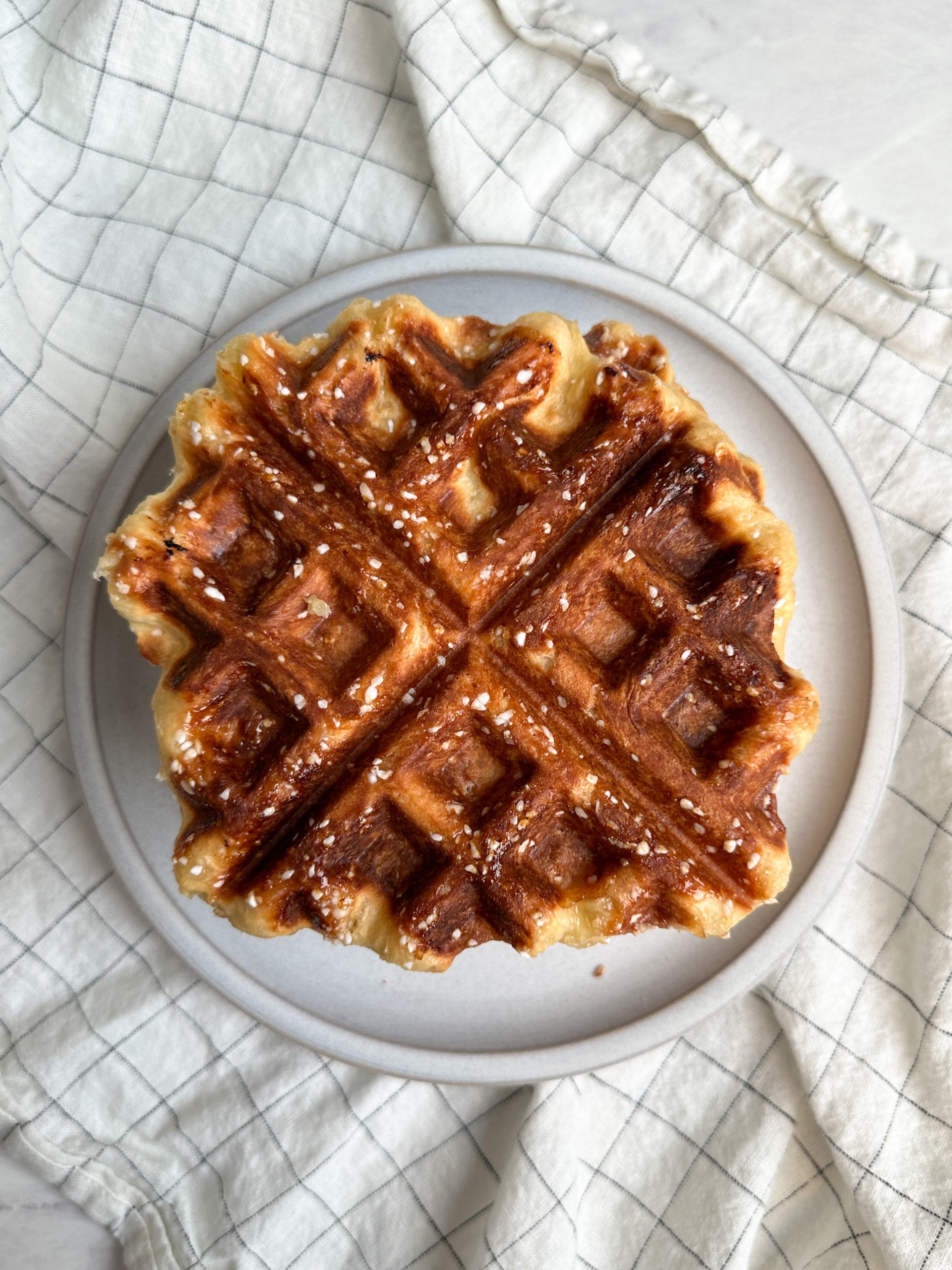 close up of a belgian liege waffle with a lovely golden color and caramelized pearl sugar on it