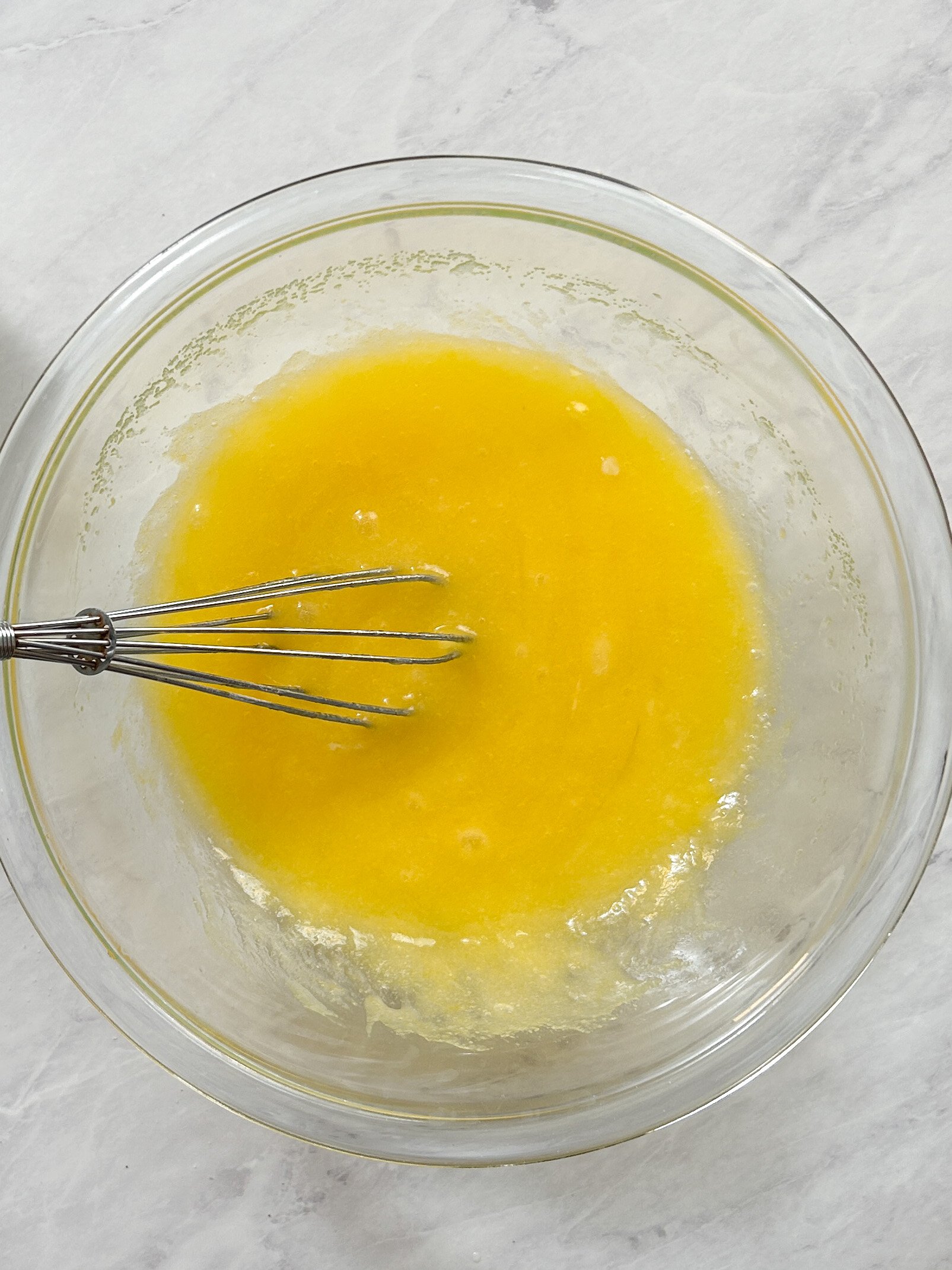 eggs mixed into butter and sugar to create cake batter