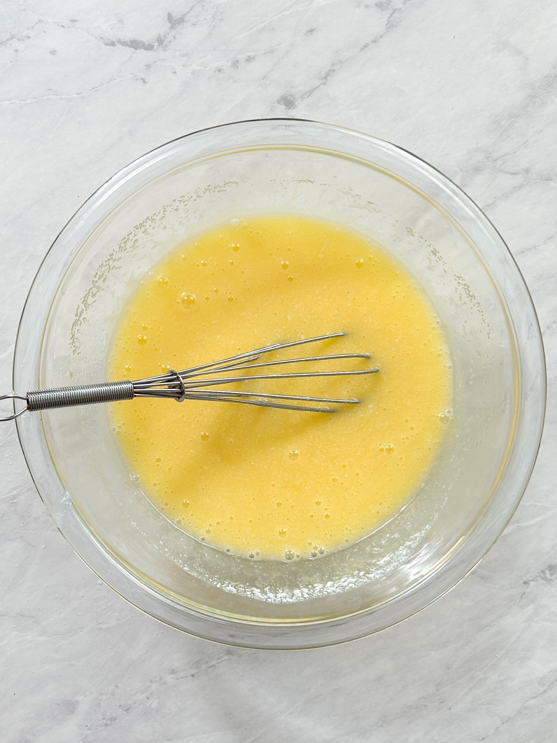 eggs mixed into butter and sugar to create cake batter