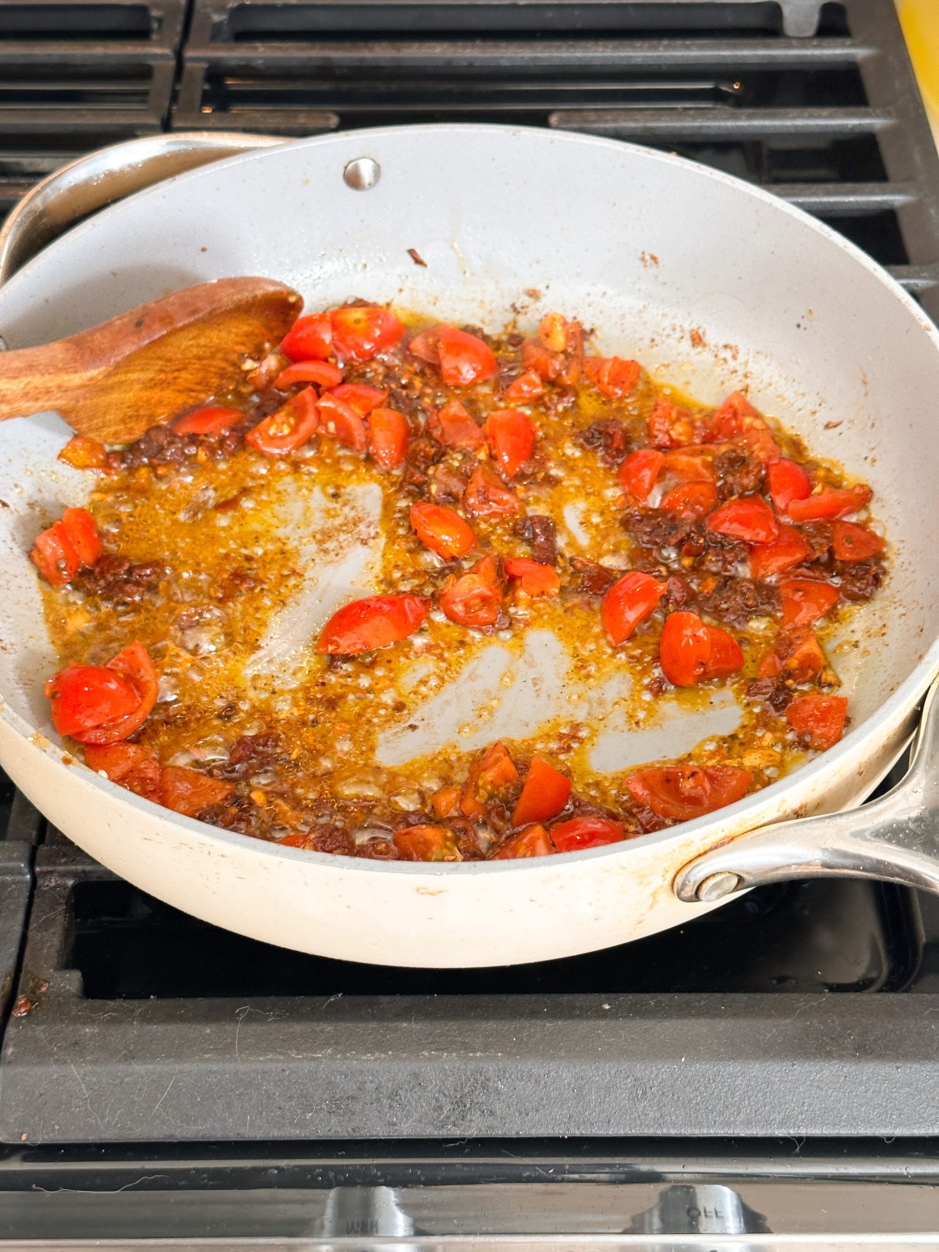 cherry tomatoes and sundried tomatoes being fried in a pan
