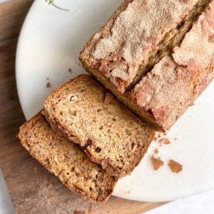 overhead image of a loaf of banana bread with cinnamon crunch with 2 slices cut revealing moist interior