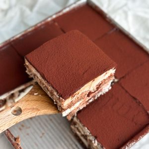 Chocolate tiramisu with layers of ladyfingers, ganache and mascarpone cream covered in cocoa powder
