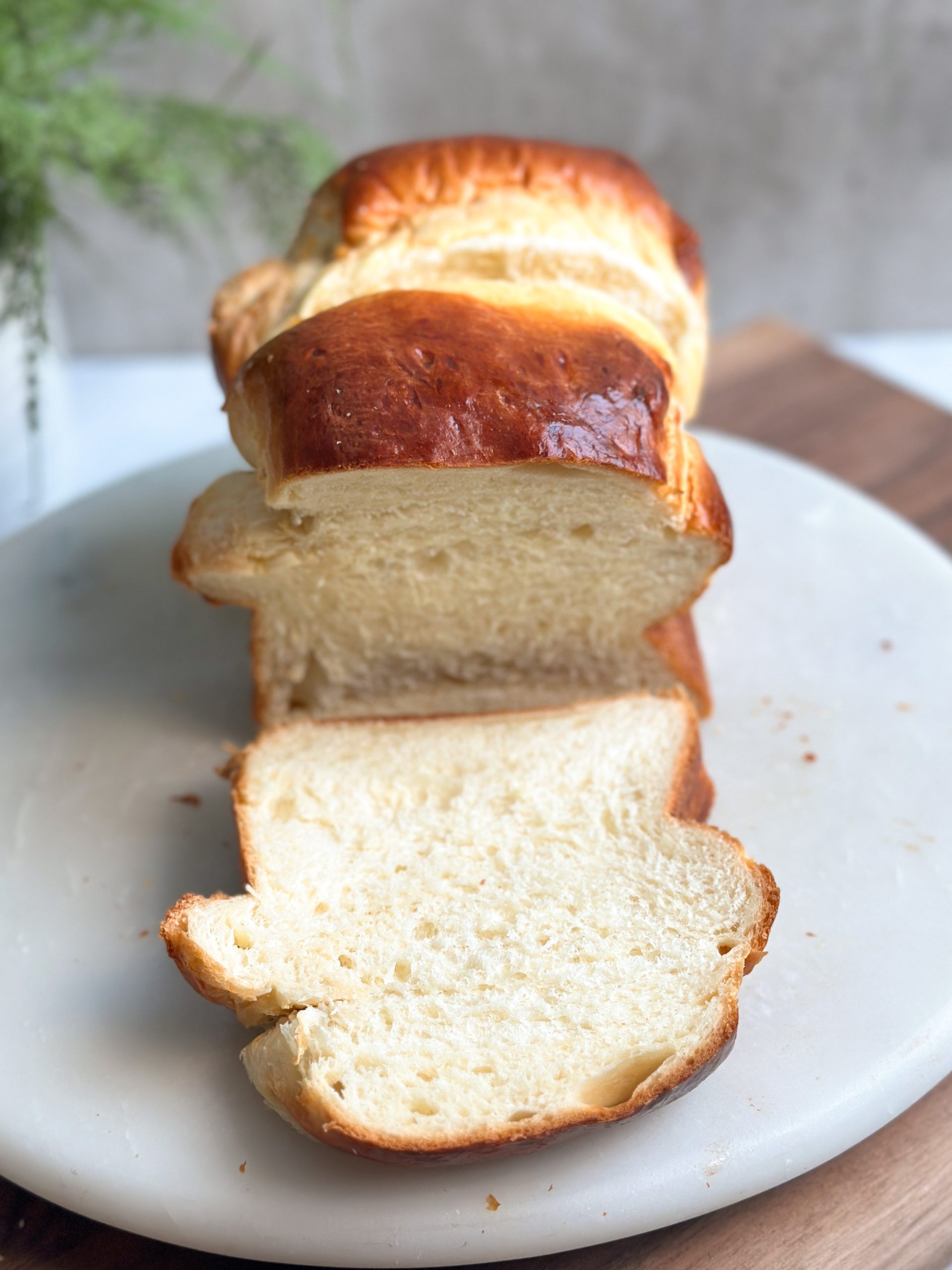 loaf of japanese milk bread sliced into thin slices showing a soft fluffy interior and golden shiny exterior