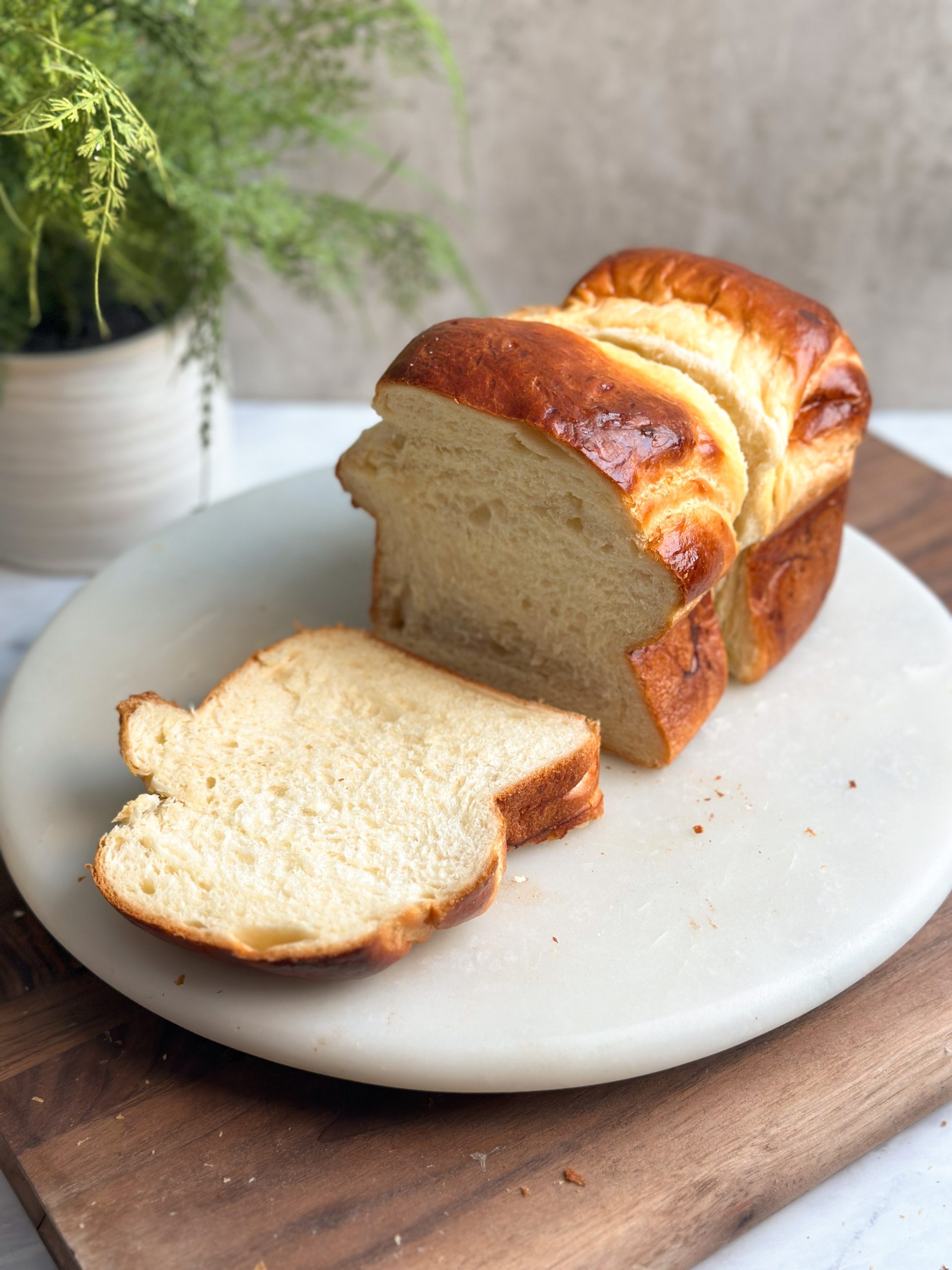 loaf of japanese milk bread sliced into thin slices showing a soft fluffy interior and golden shiny exterior
