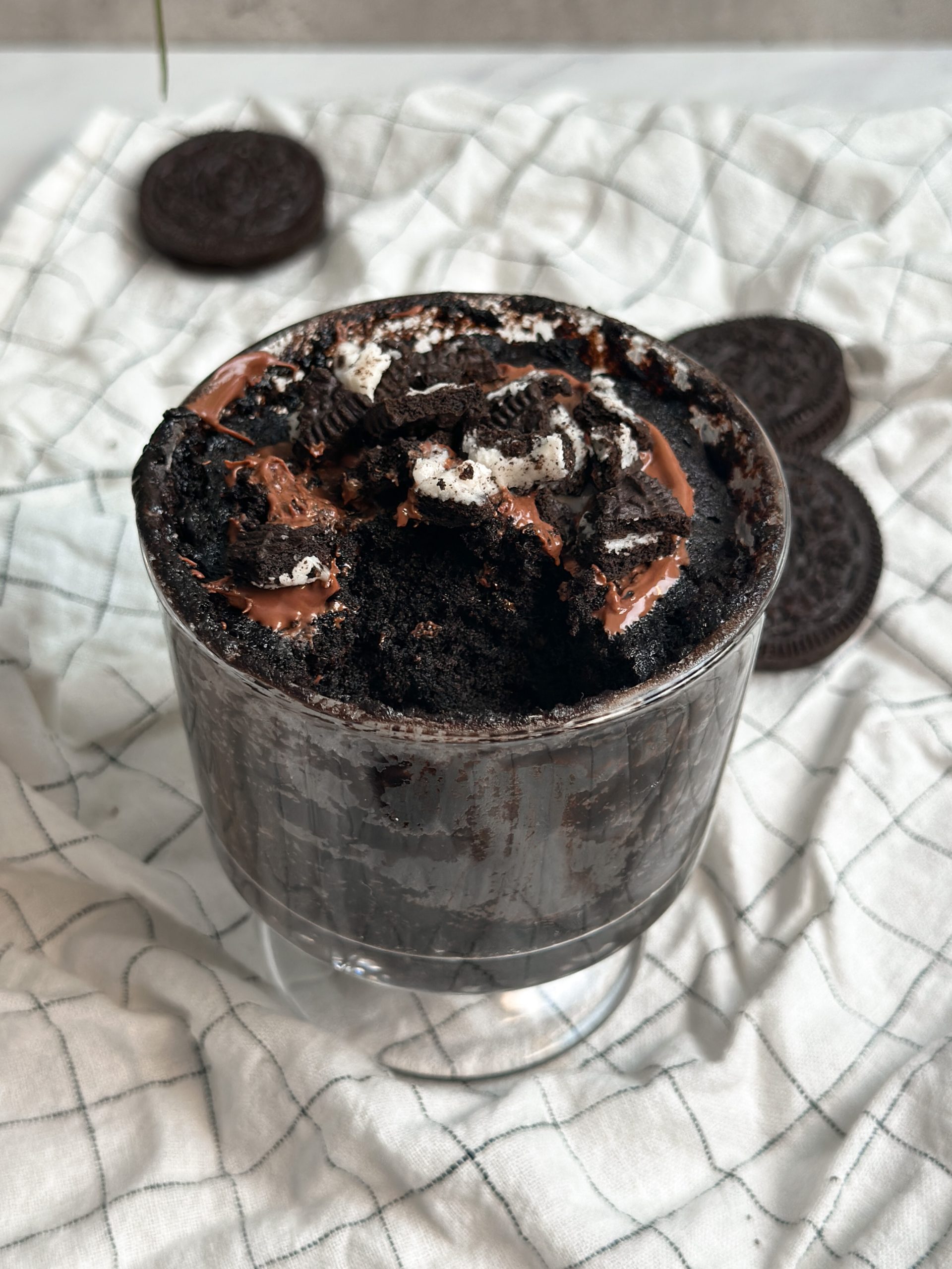 oreo chocolate mug cake with a bite taken out of it revealing moist chocolatey interior