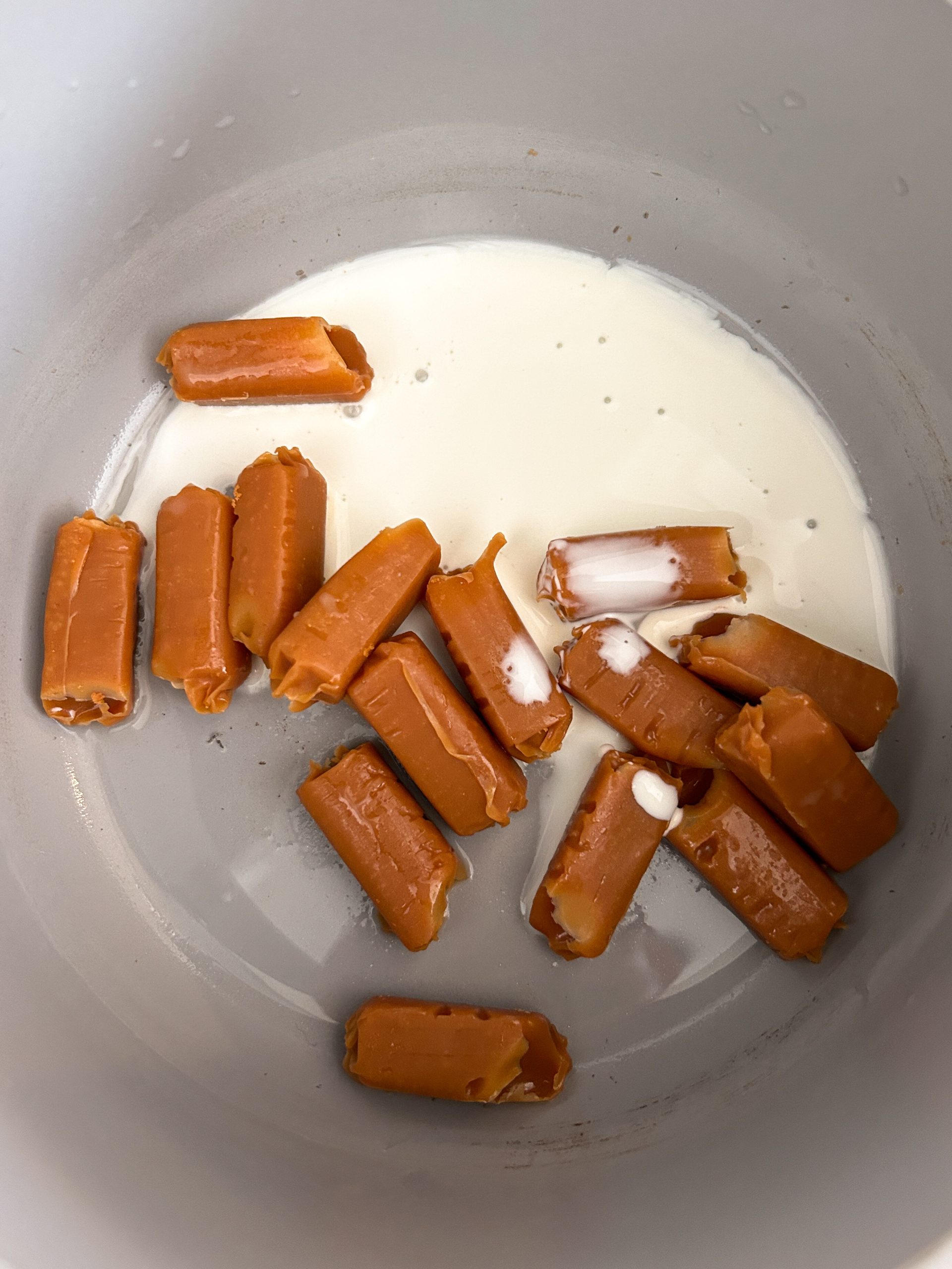 chewy caramels and cream in a saucepan