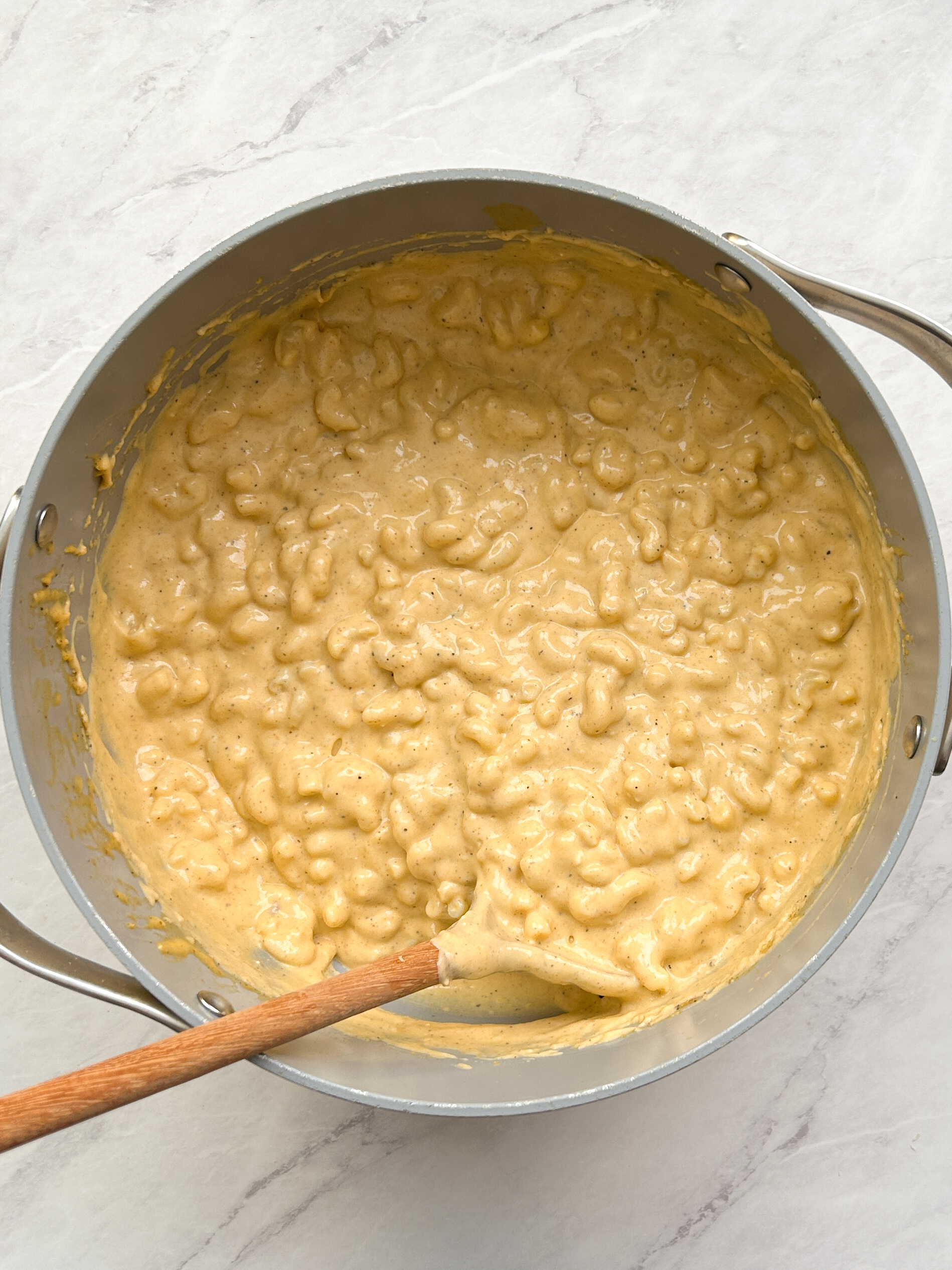 mac and cheese mixture in a dutch oven pan with a creamy cheesy texture