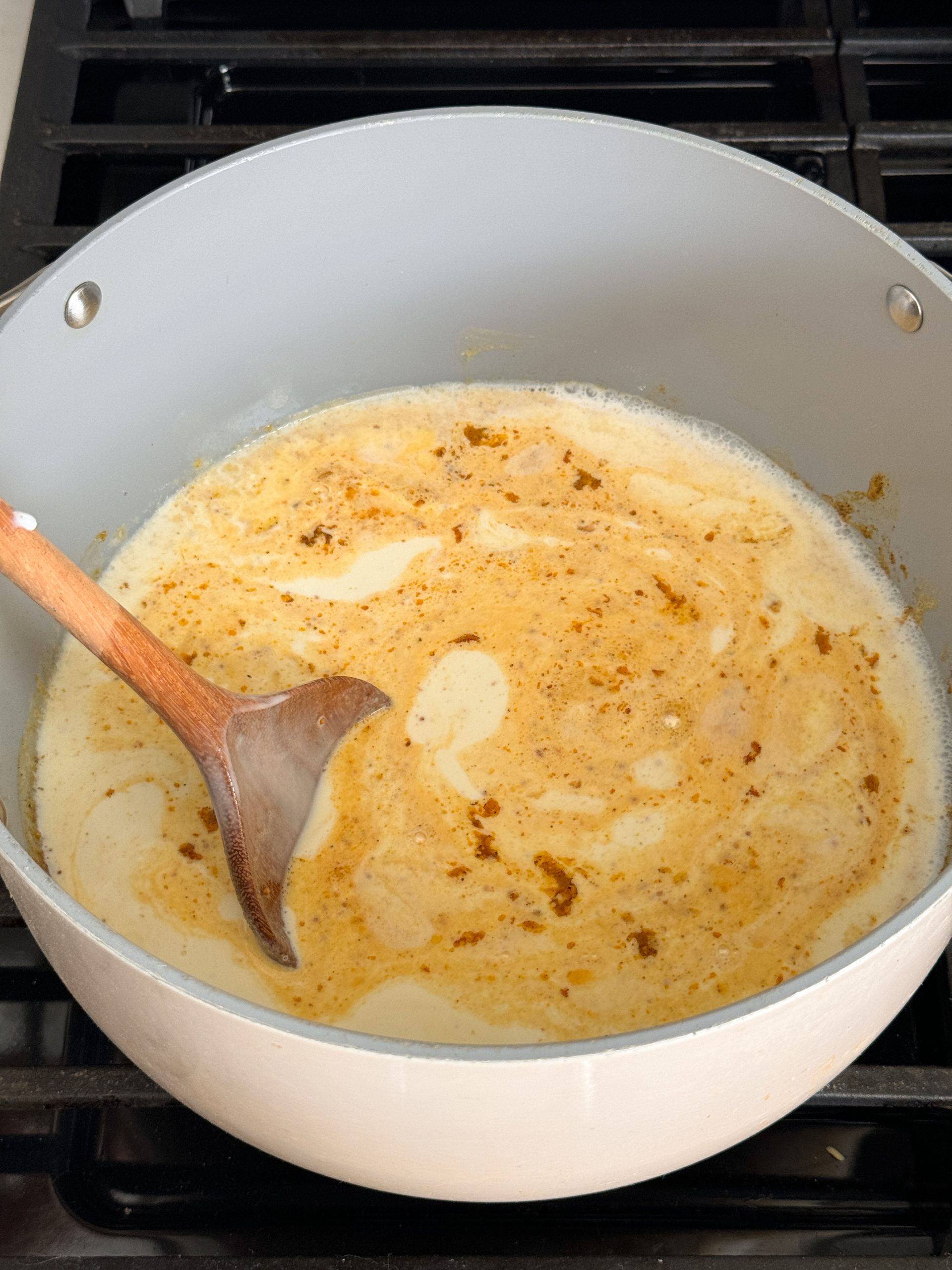 milk added to cheese sauce mixture in a dutch oven pan