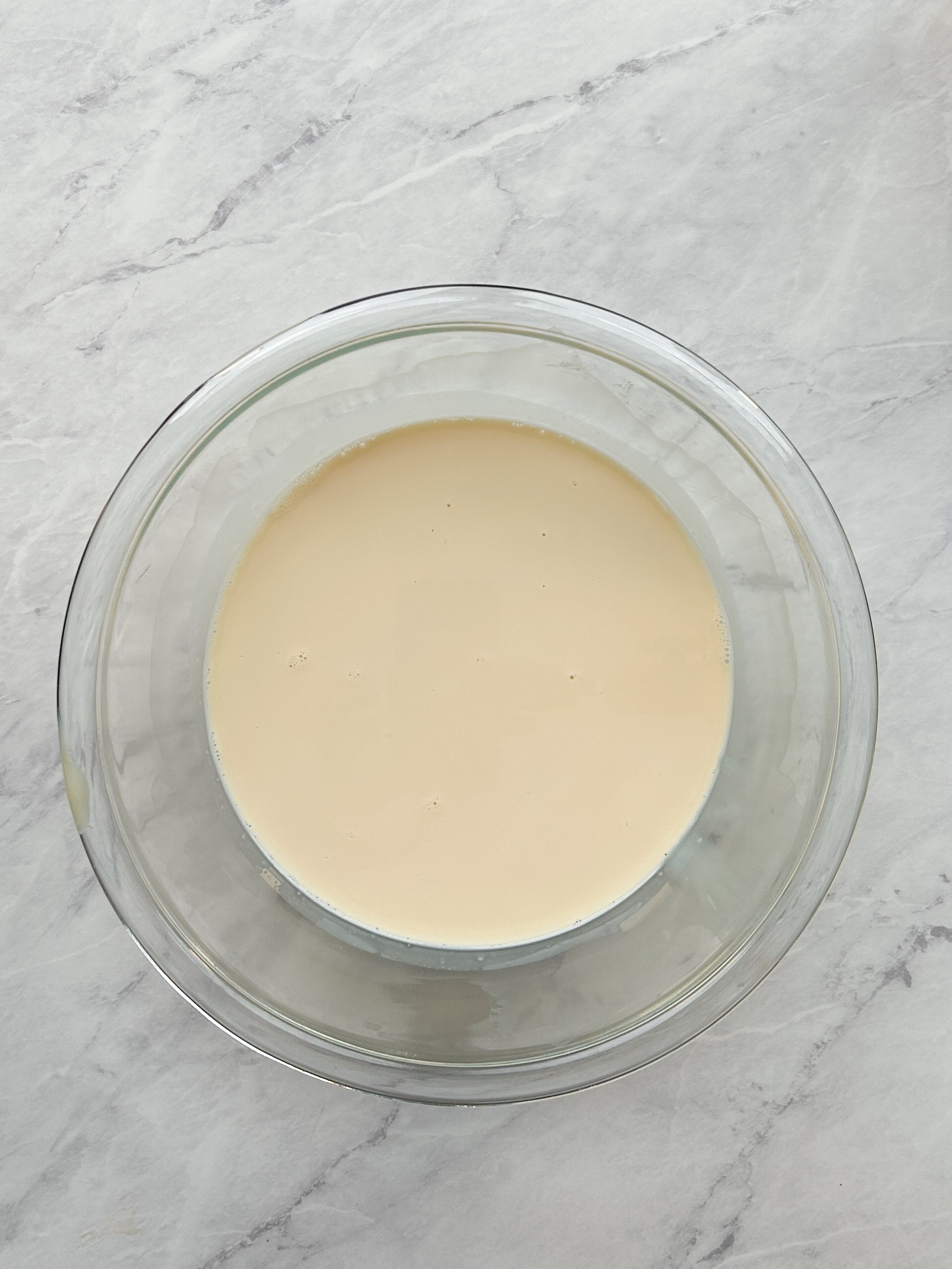 evaporated milk and sweetened condensed milk in a glass bowl