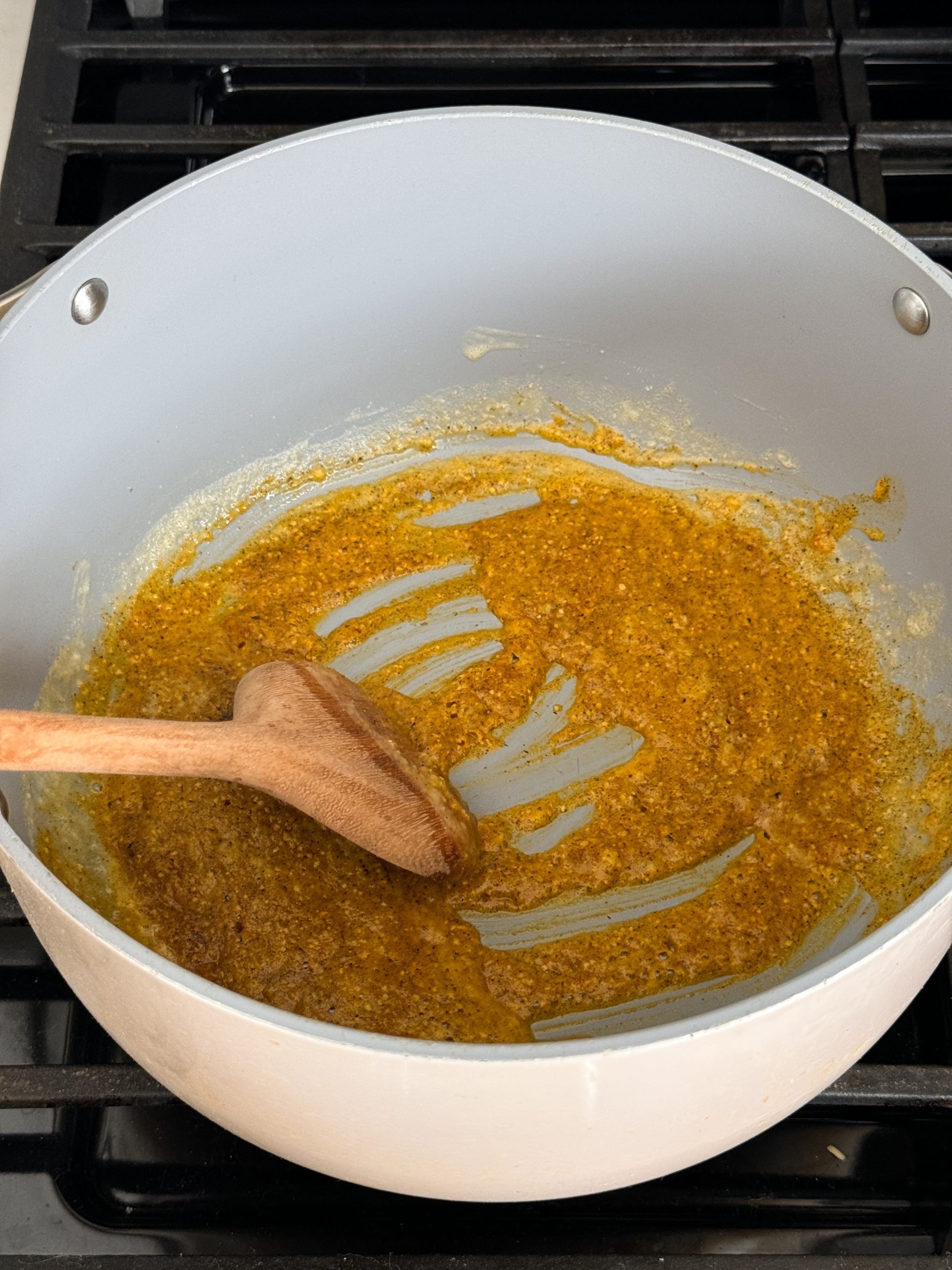spices added to butter and flour in a dutch oven pan and being mixed together