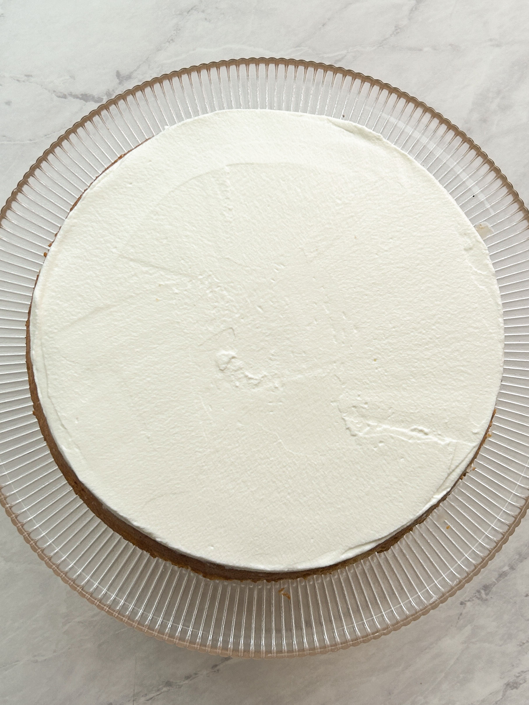 whipped cream spread on top of a tres leches cake