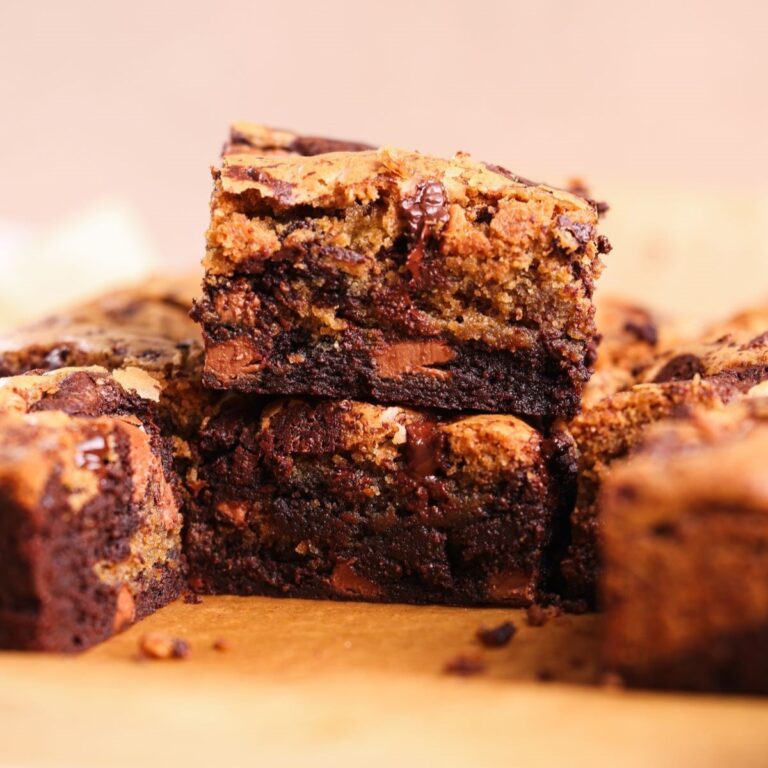 side image of brookies with one brookie placed on top of another. the brookies are a mixture of chocolate chip cookie and brownie with lots of molten chocolate
