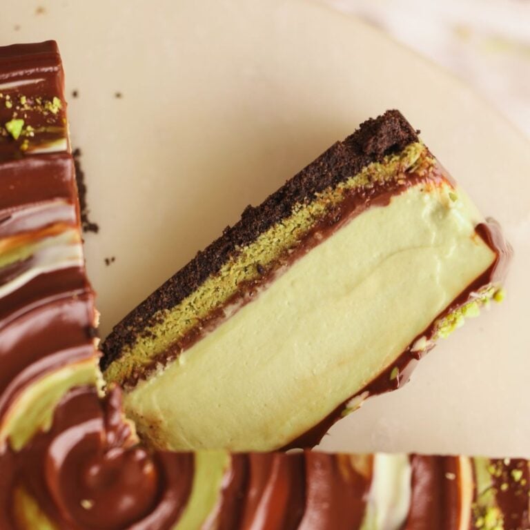 slice of dubai chocolate cheesecake placed sideways next to the cheesecake pictured from above