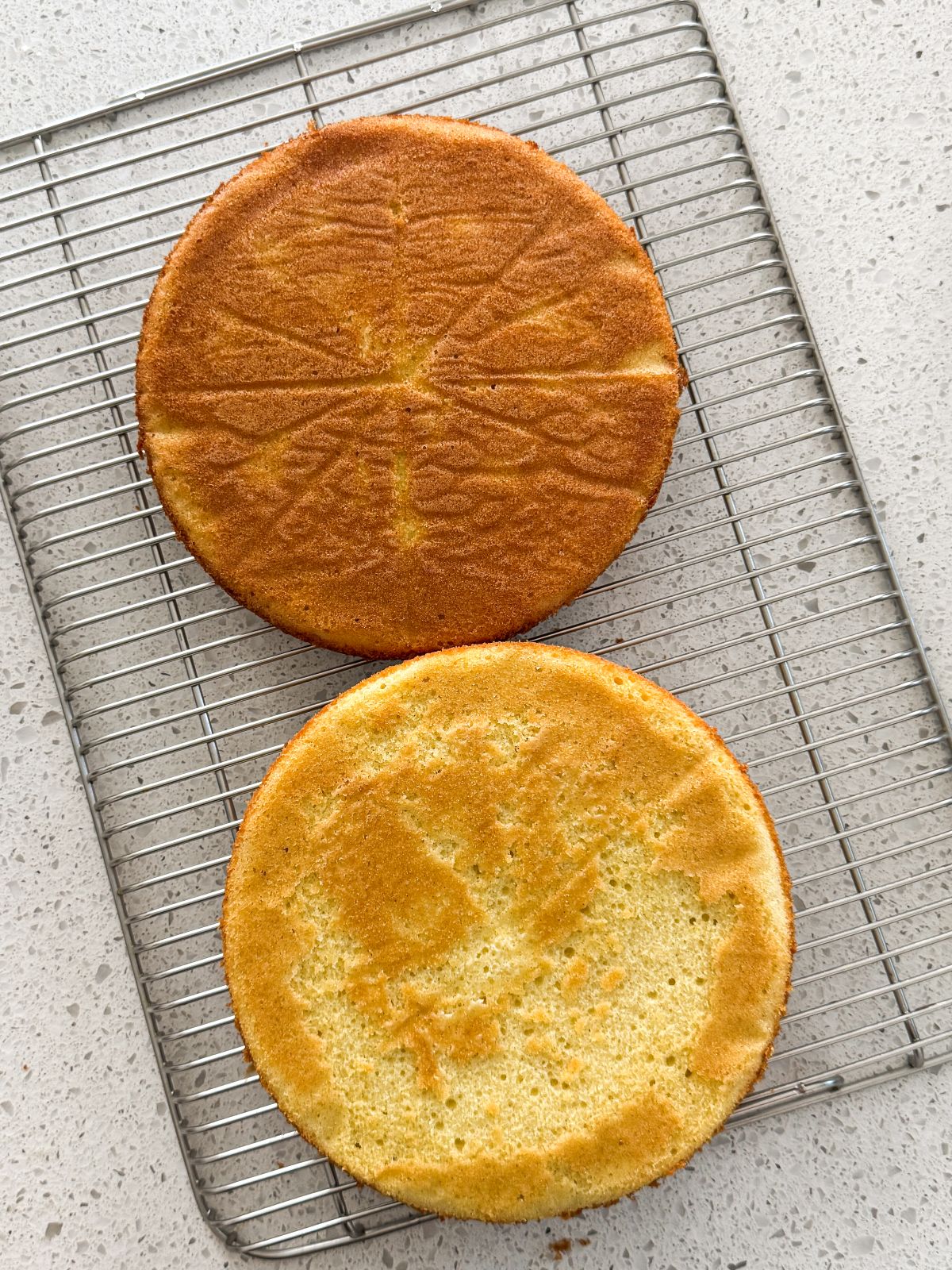 2 cooked cakes on a wire rack. cakes have a light golden color