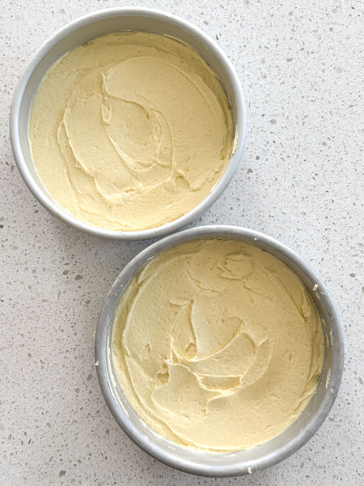 2 cake pans filled with cake batter