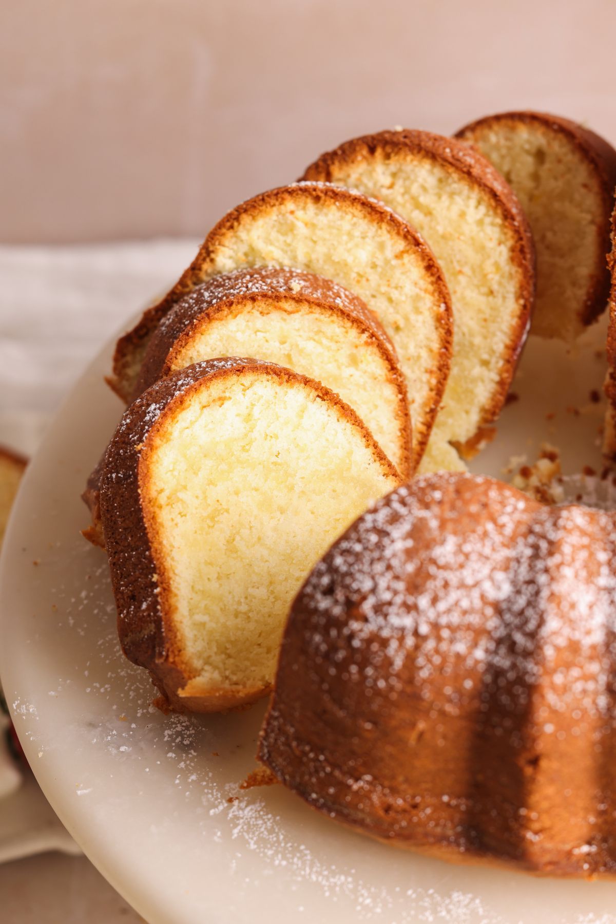 sliced pound cake on a marble stand with the slices leaning on each other