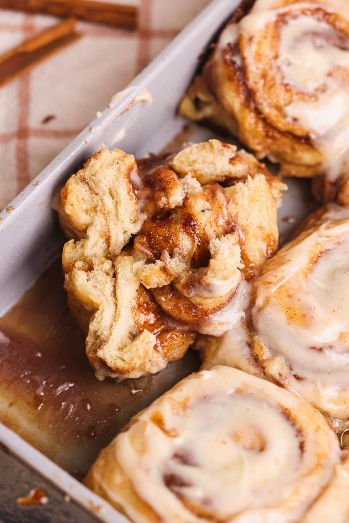 close up of a banana bread cinnamon roll torn into half to show the soft texture and gooey filling