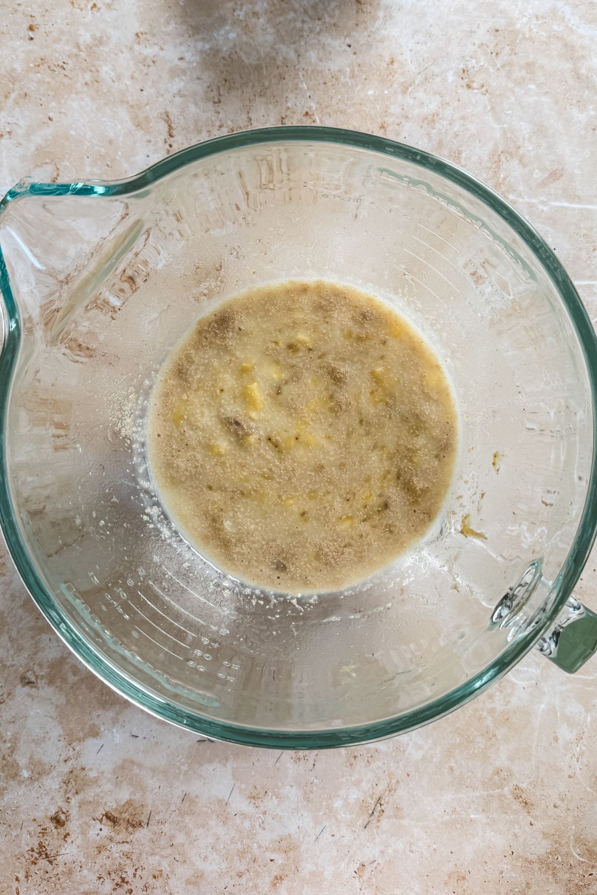 a mixture of sugar, banana, milk and yeast in a glass bowl
