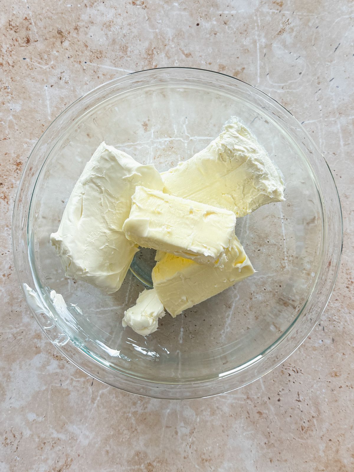 blocks of cream cheese and butter in a glass bowl