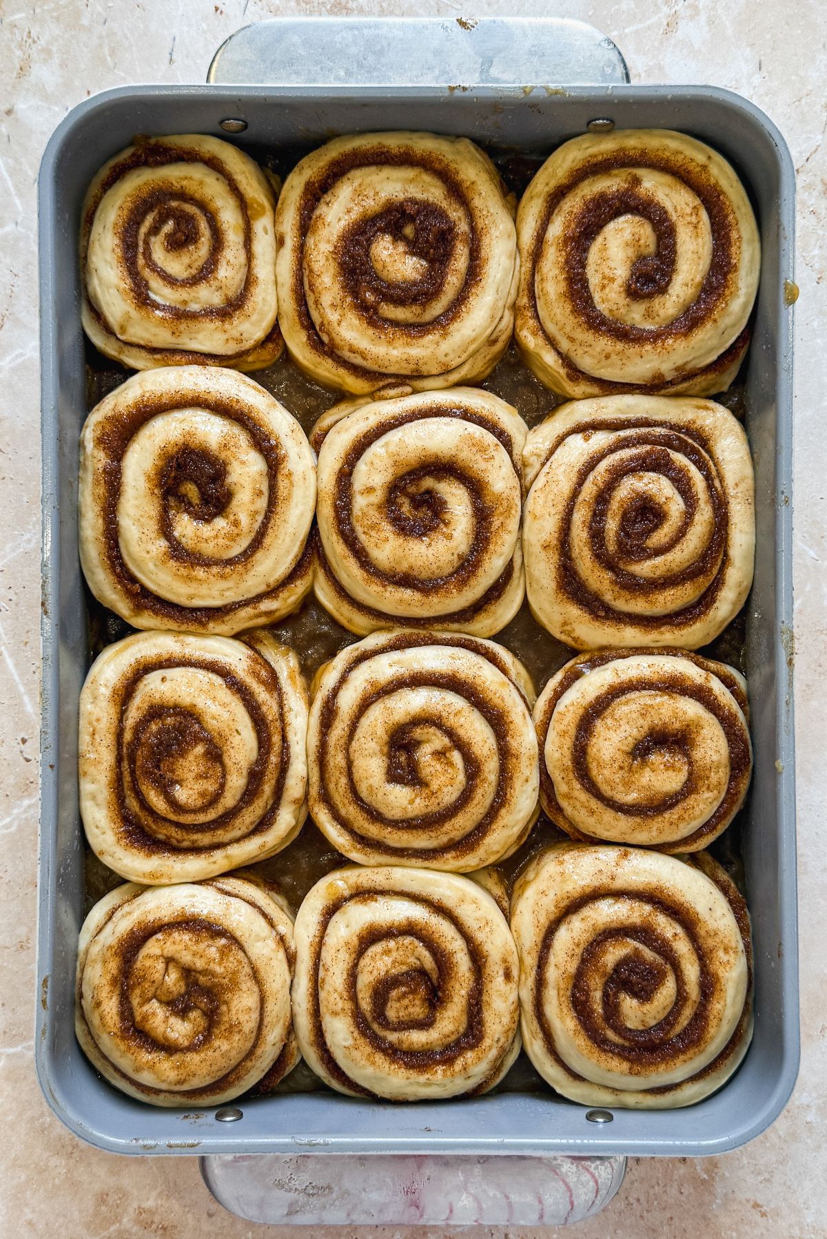 12 banana cinnamon rolls shaped and placed in a rectangular pan