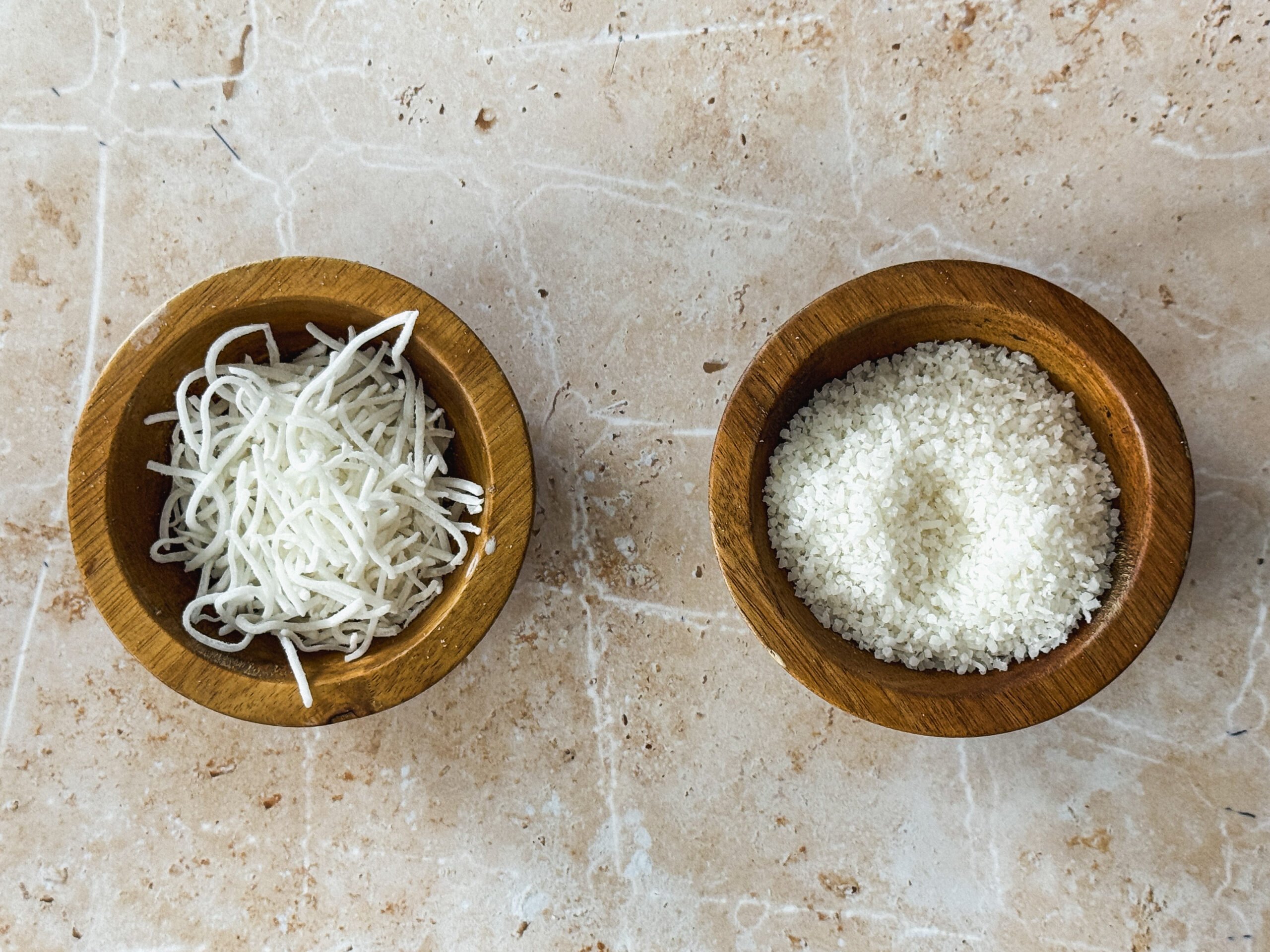 2 small bowls, one with long strands of coconut and one with small coconut crumbs