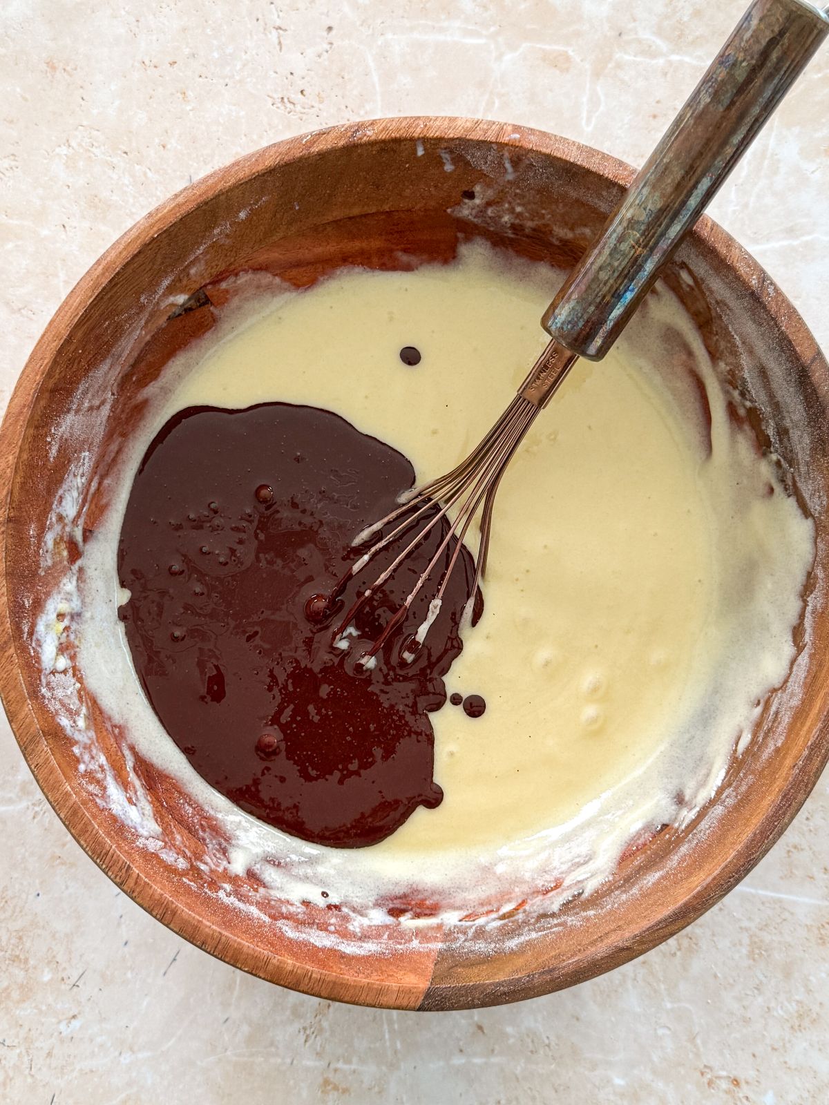 bloomed cocoa powder mixture poured on top of cake batter in a wooden bowl