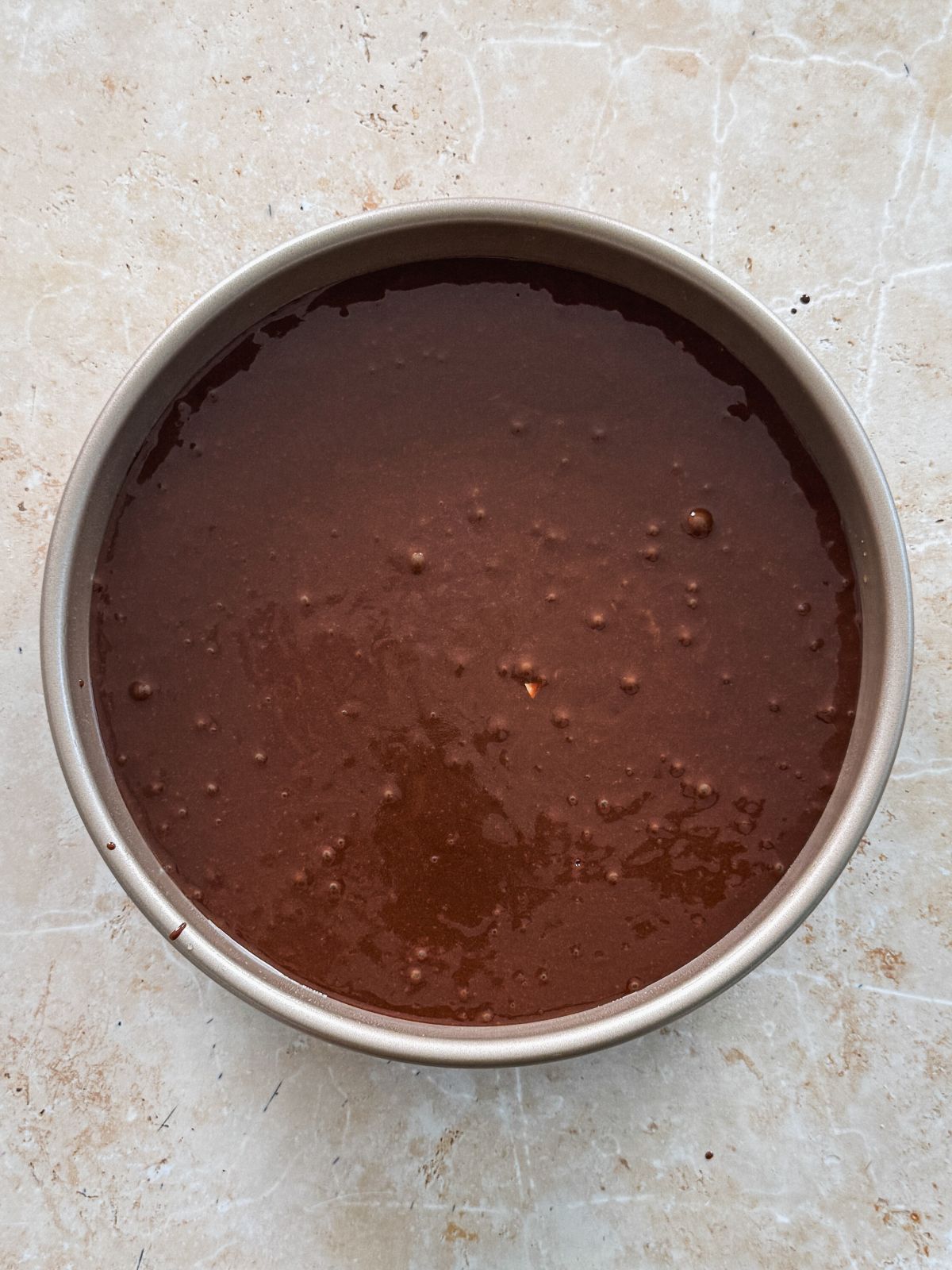 chocolate cake batter in a round cake pan